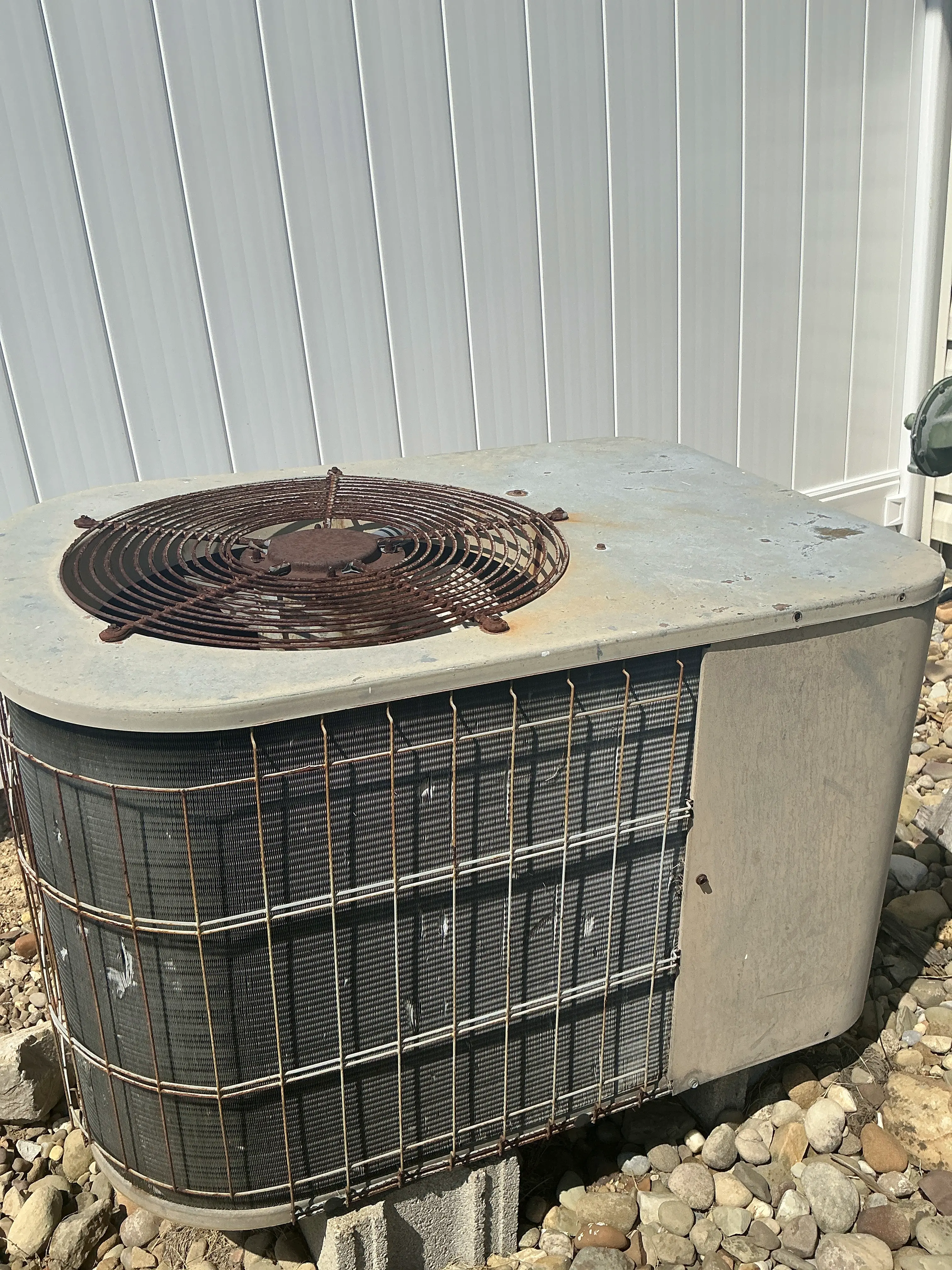 Aged and rusted air conditioner condenser unit outside a home 2026-08-20