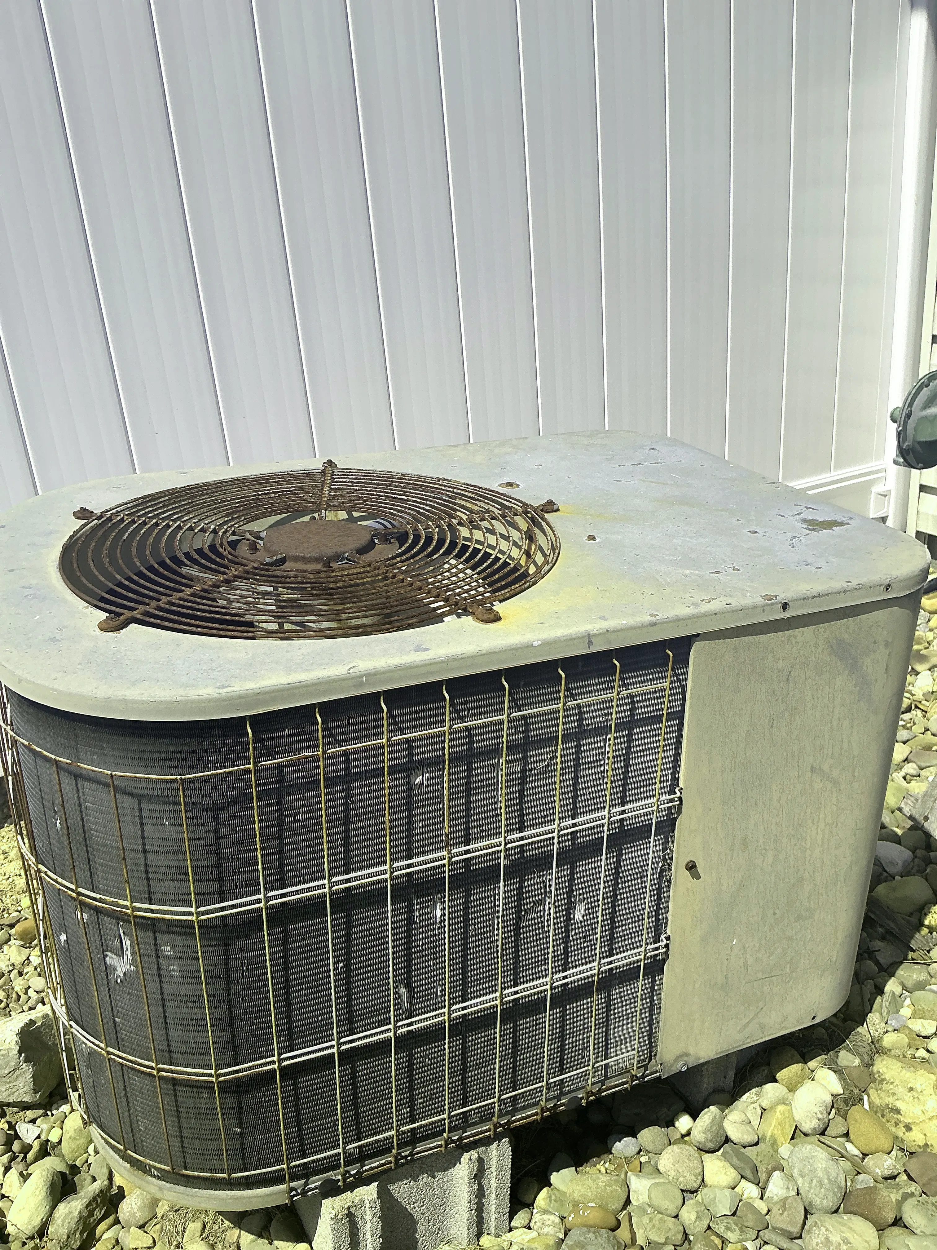 Aged and rusted air conditioner condenser unit outside a home 2026-09-02