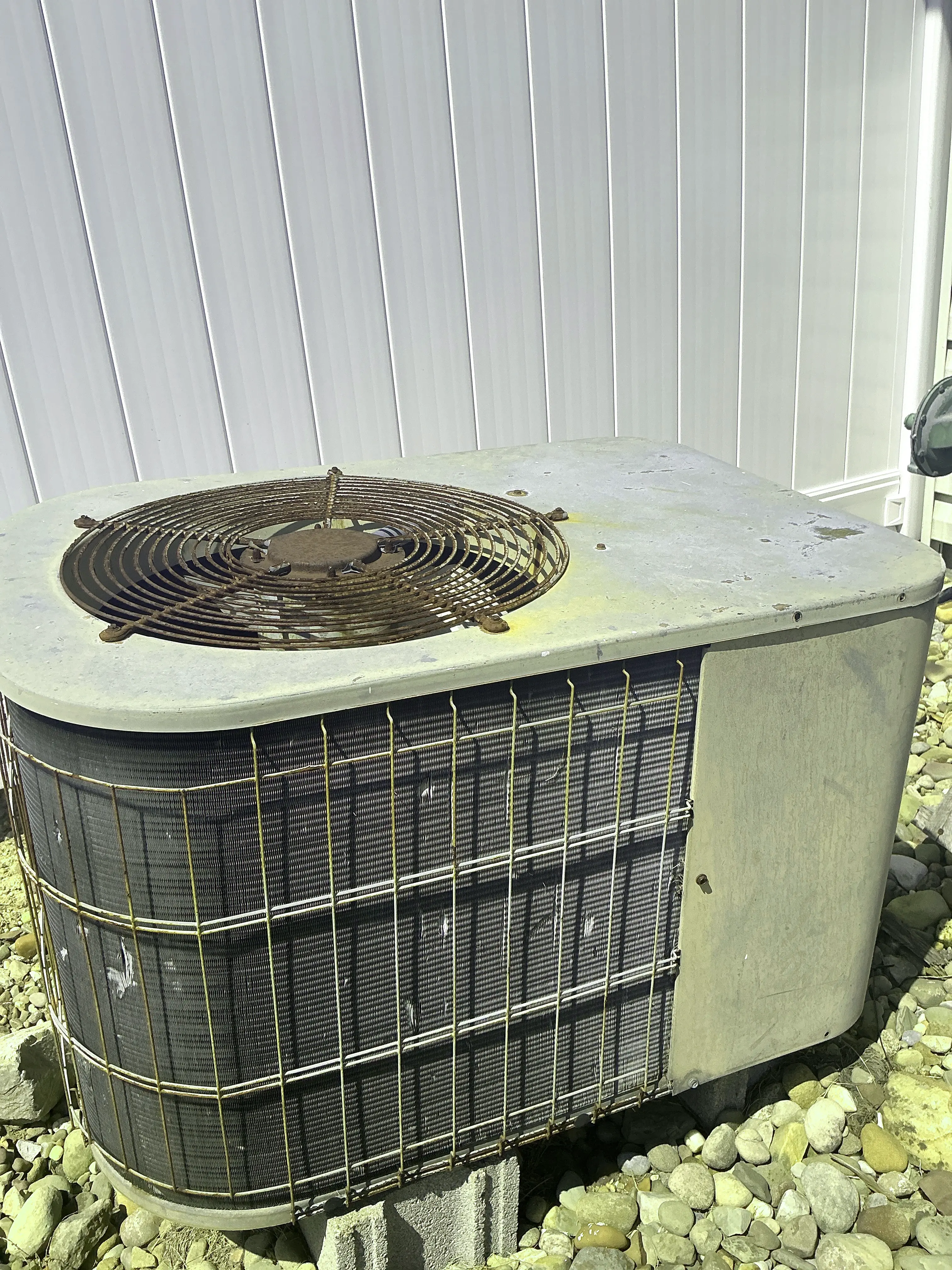 Aged and rusted air conditioner condenser unit outside a home 2026-08-11