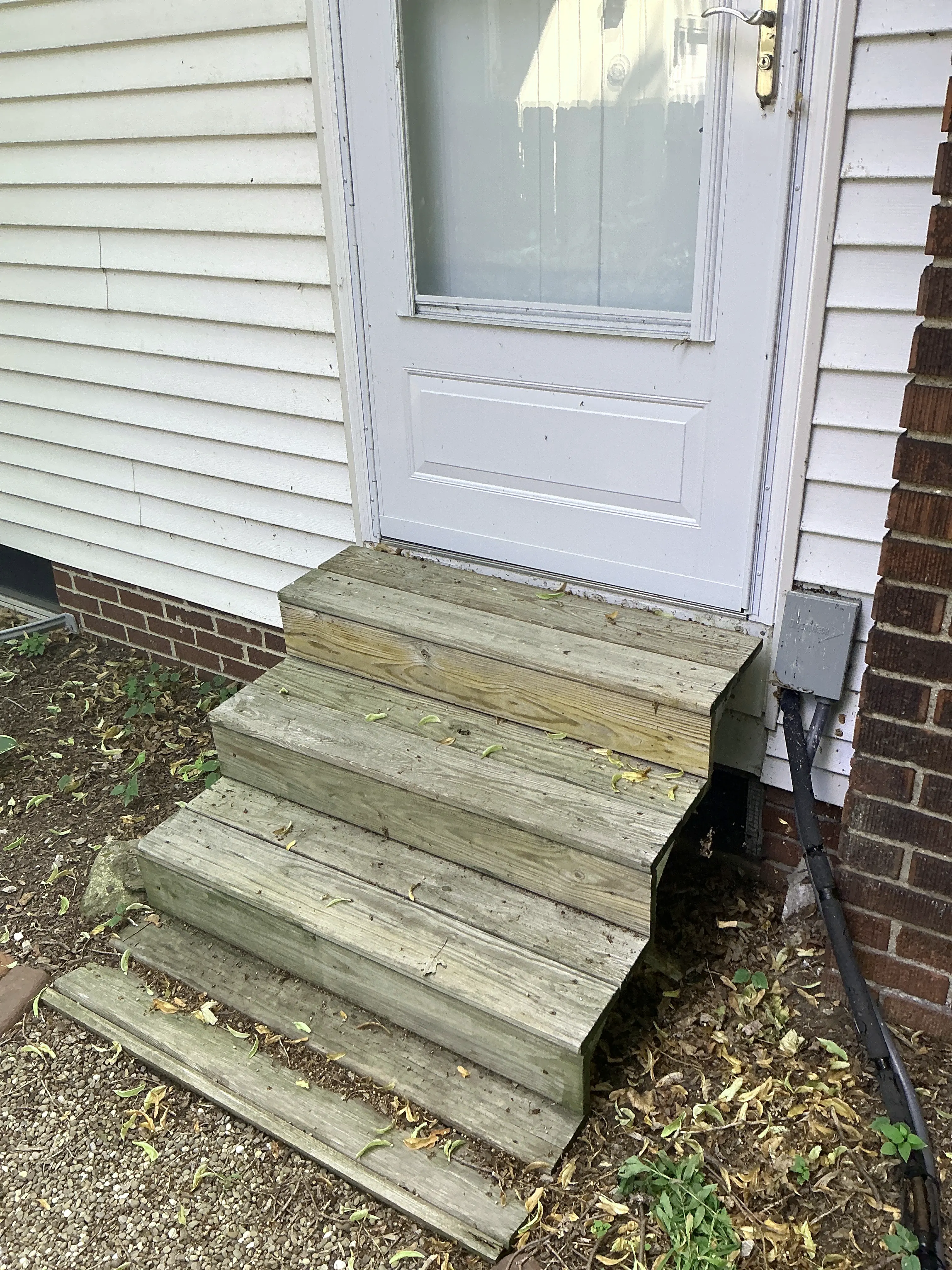 Exterior wooden stairs leading up to a side entrance door of a home 2026-07-14