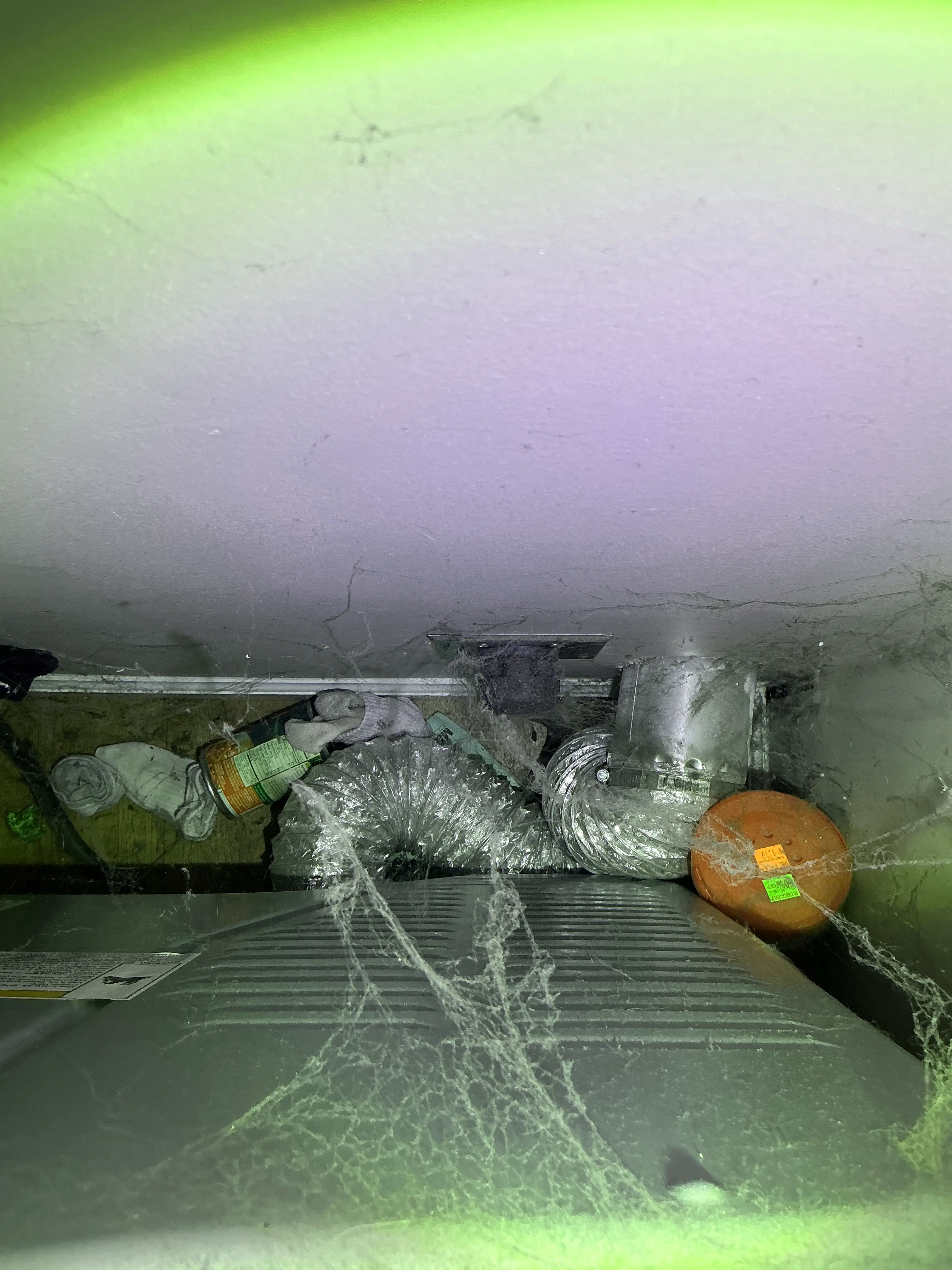Dust, cobwebs, and trash debris buildup behind dryer vent transition pipe during home inspection 2026-08-14