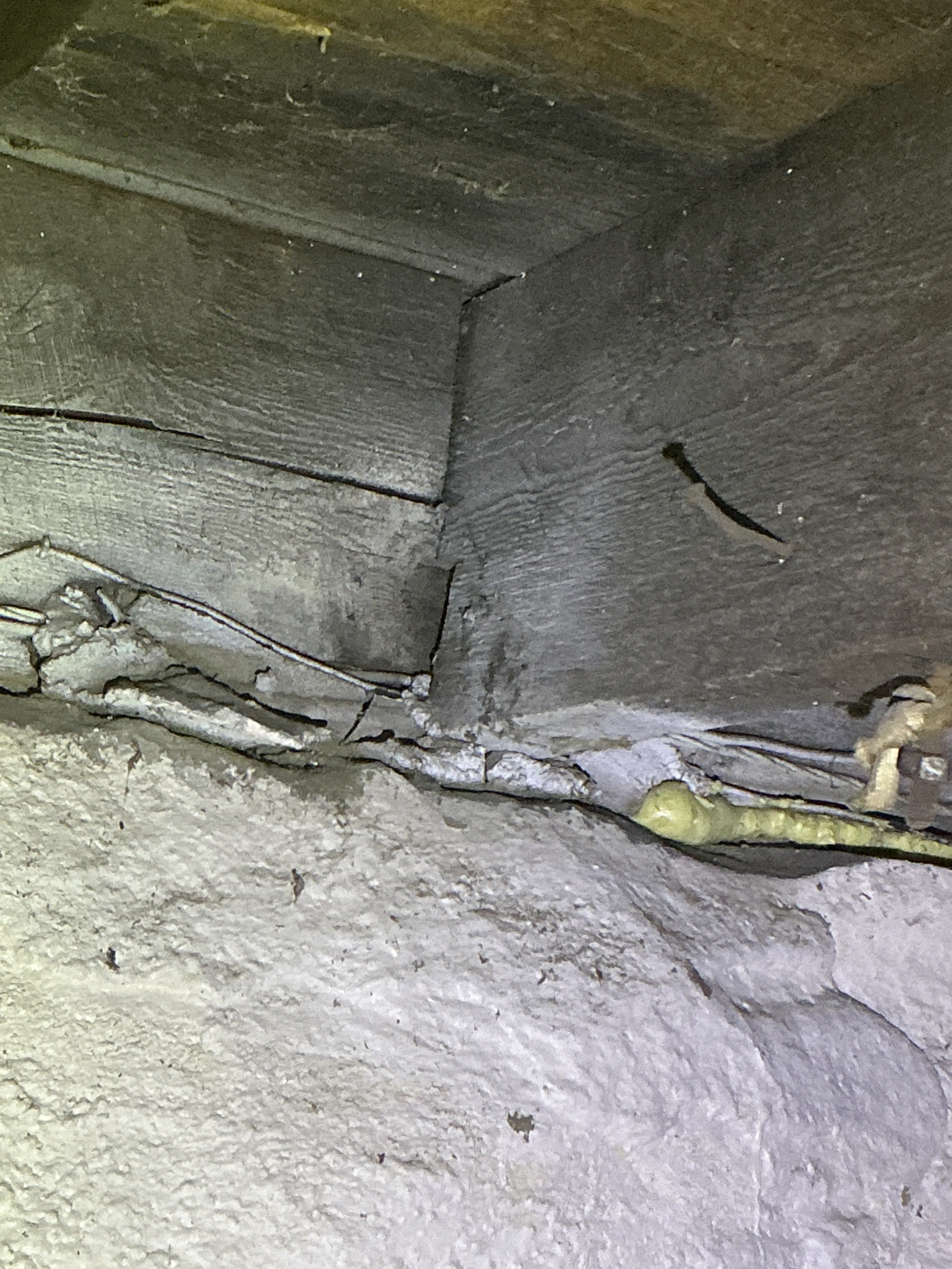 Wooden floor joist and sill area meeting foundation wall with unsealed gaps. 2026-07-11