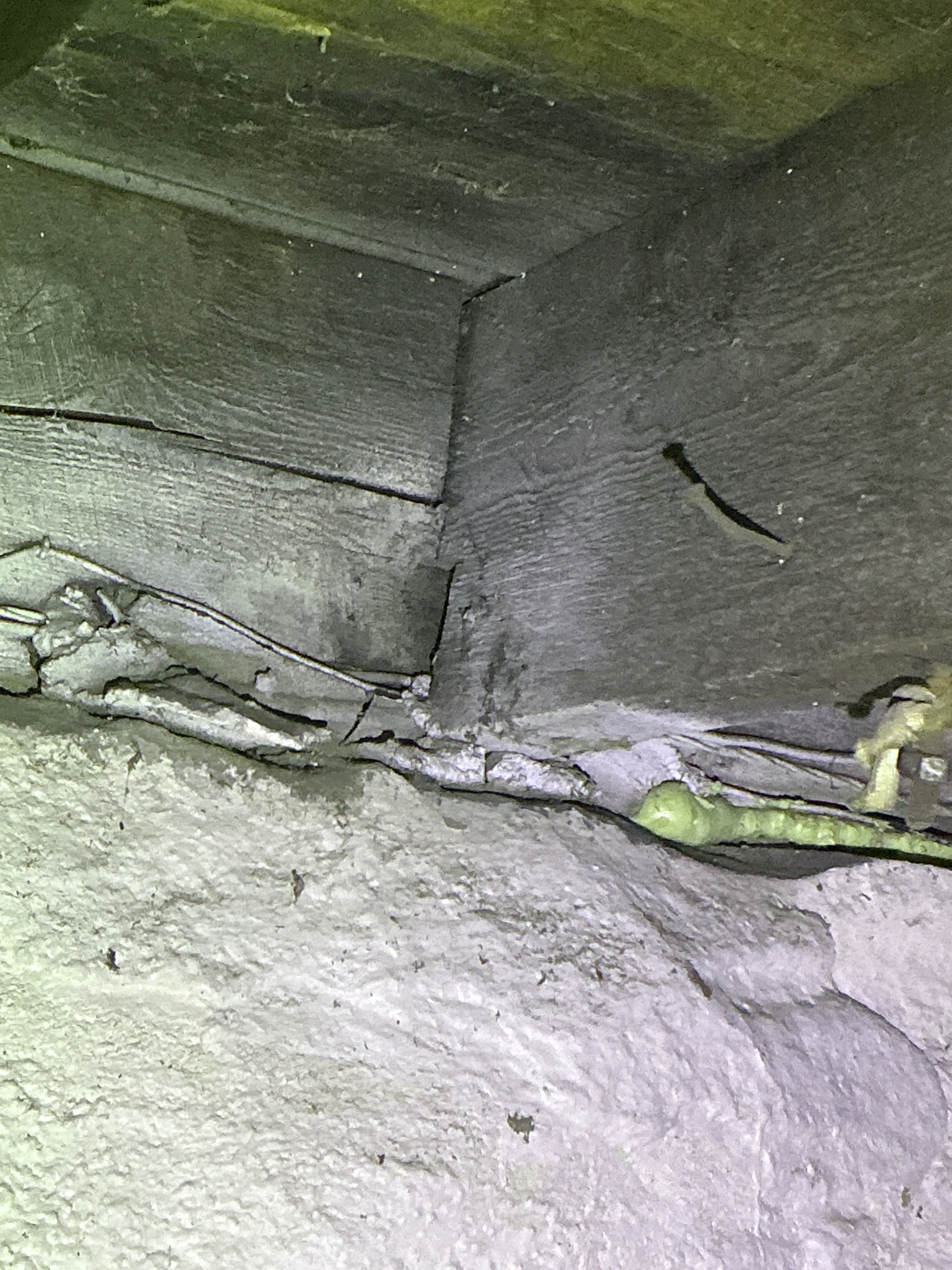 Wooden floor joist and sill area meeting foundation wall with unsealed gaps. 2026-07-26