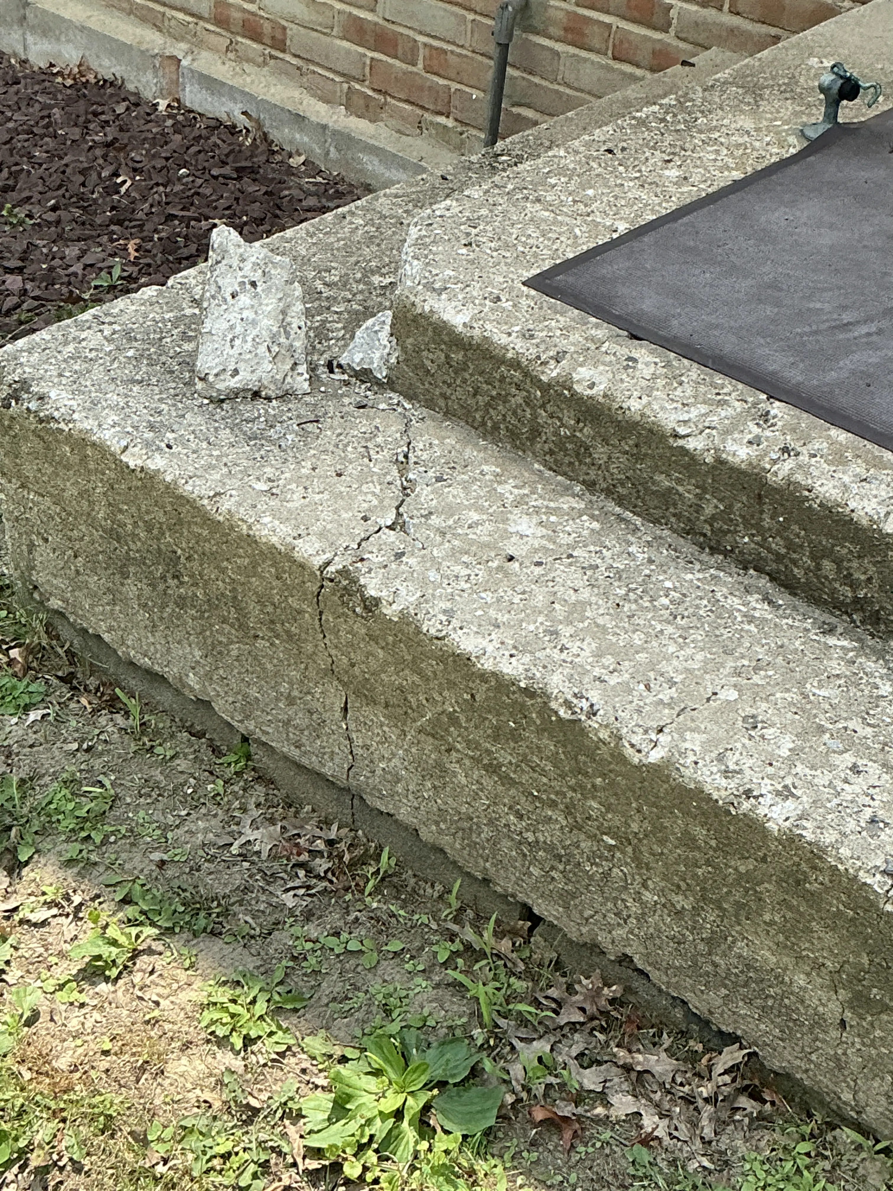 Cracked and spalled concrete step exterior during a lead inspection 2026-07-31