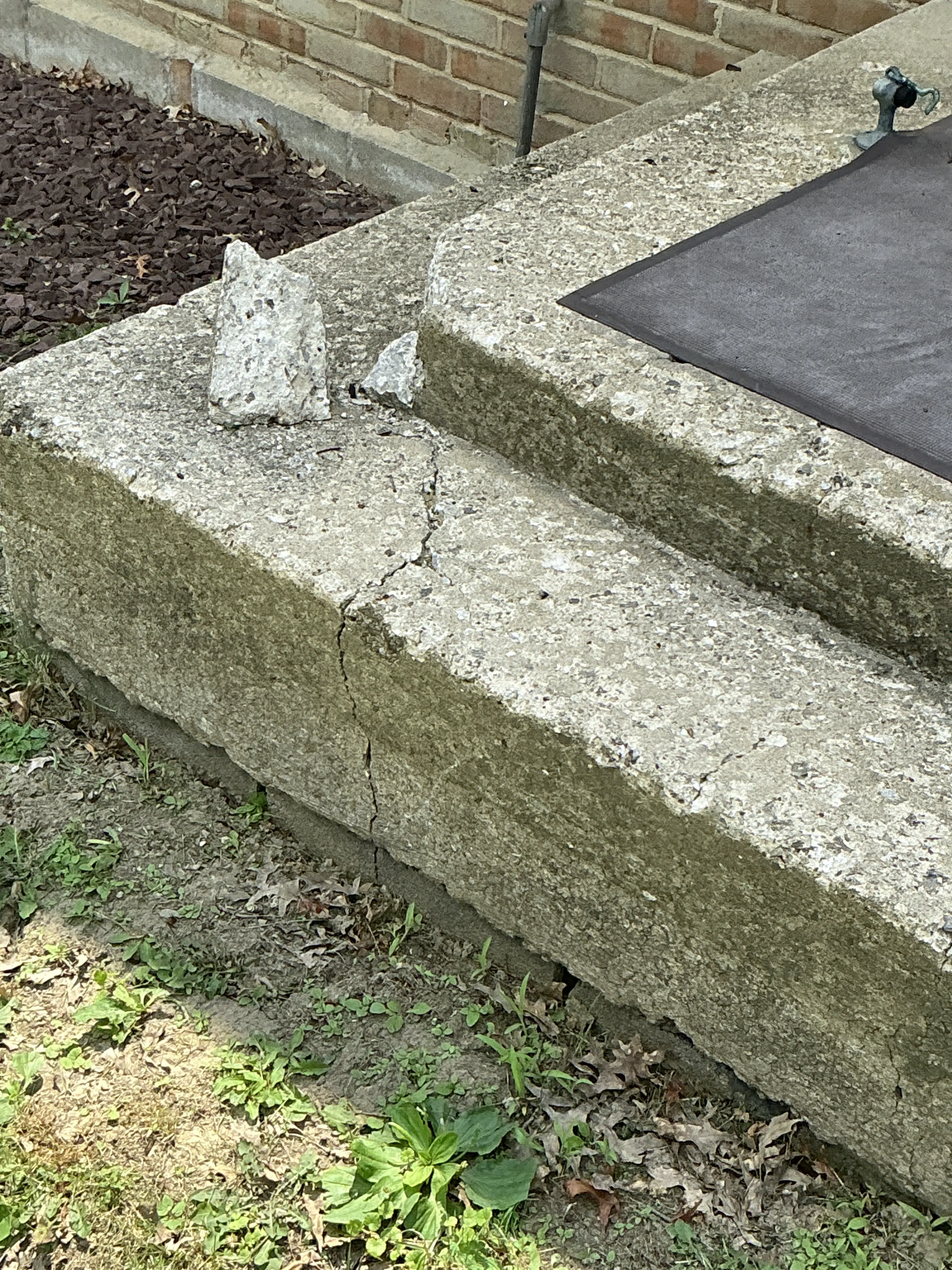 Cracked and spalled concrete step exterior during a general inspection 2026-08-25