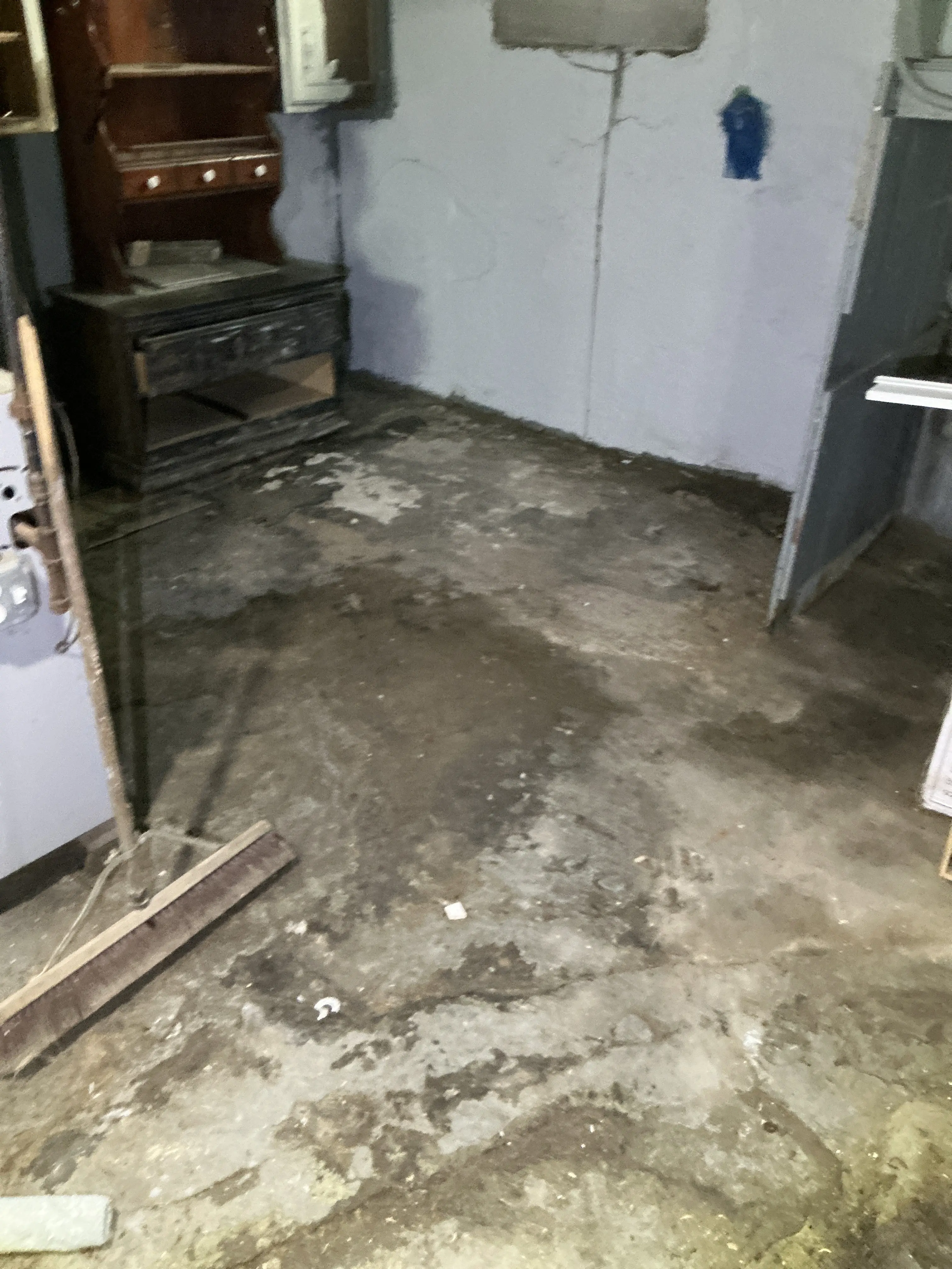 Unfinished concrete basement floor with dark water stains and moisture intrusion 2026-07-29
