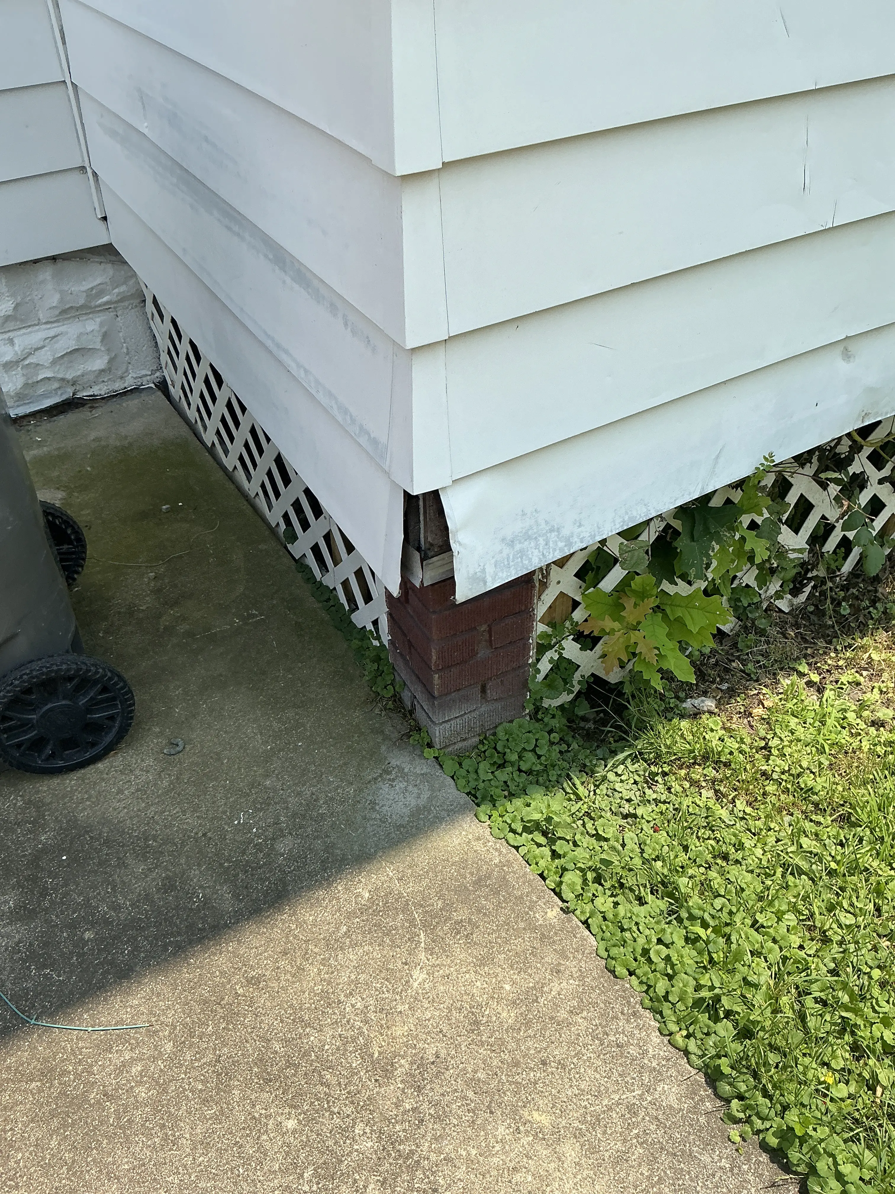 Damaged siding corner trim exposing exterior wood framing near foundation 2026-07-20