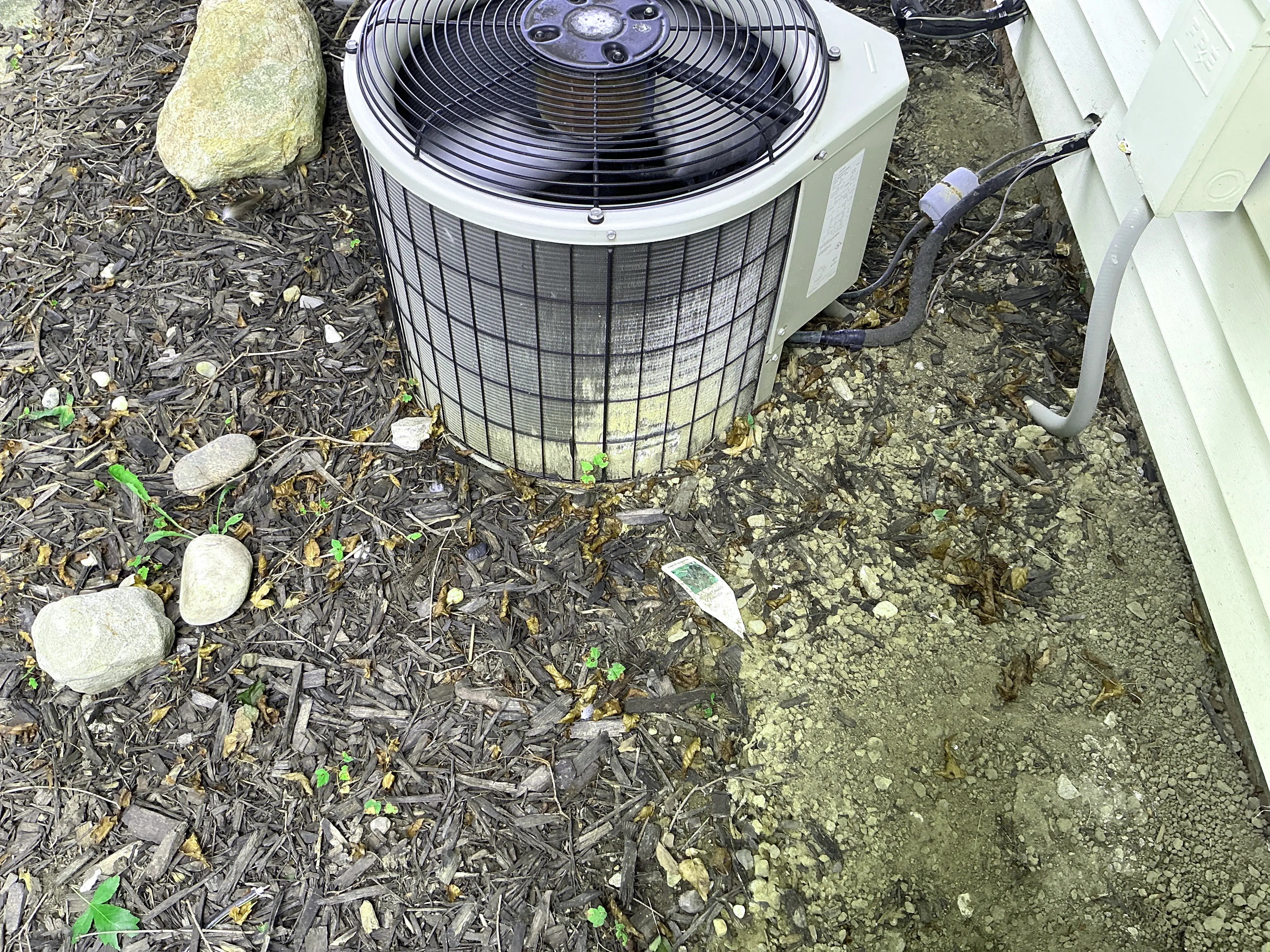 Outdoor air conditioner condenser unit with dirty coils next to house siding 2026-08-30