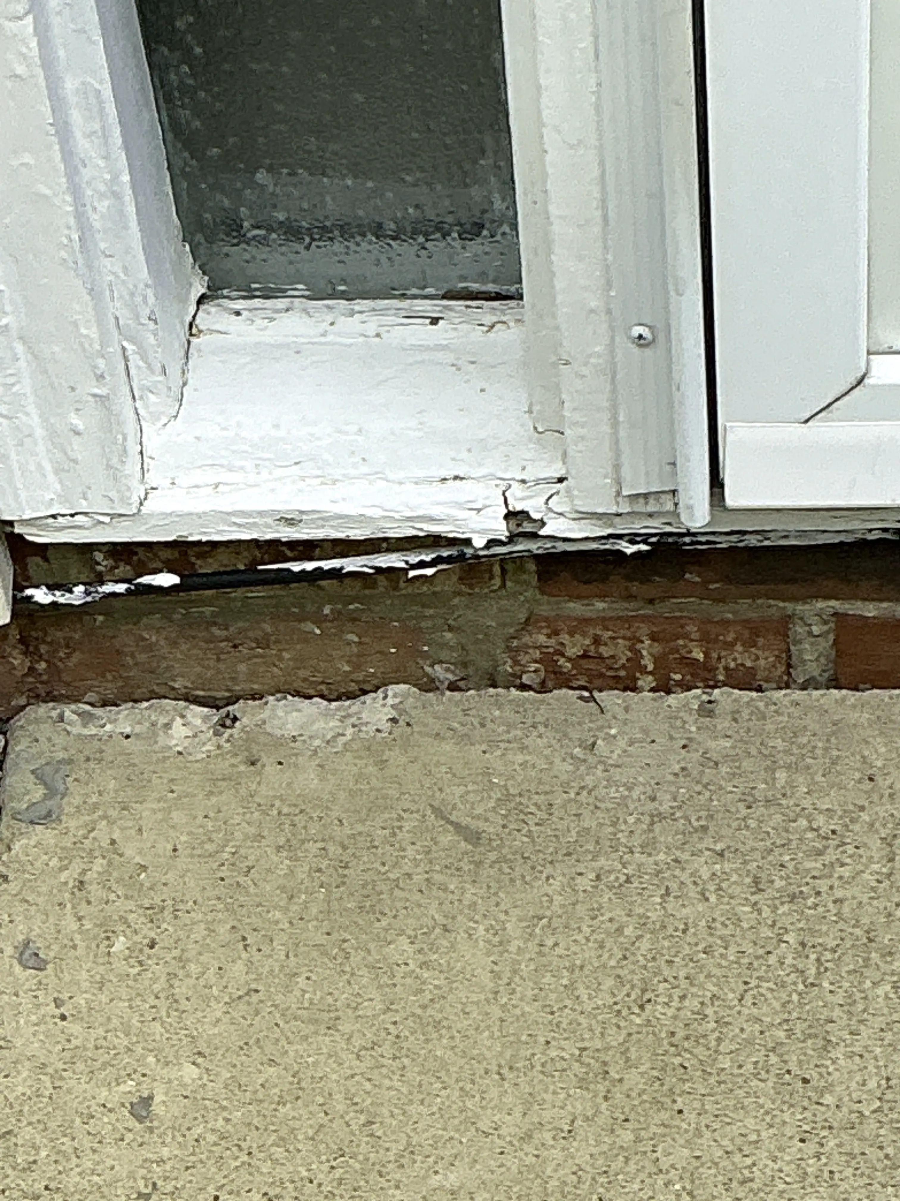 Unsealed gap between window frame and brick exterior wall needing caulking 2026-07-22