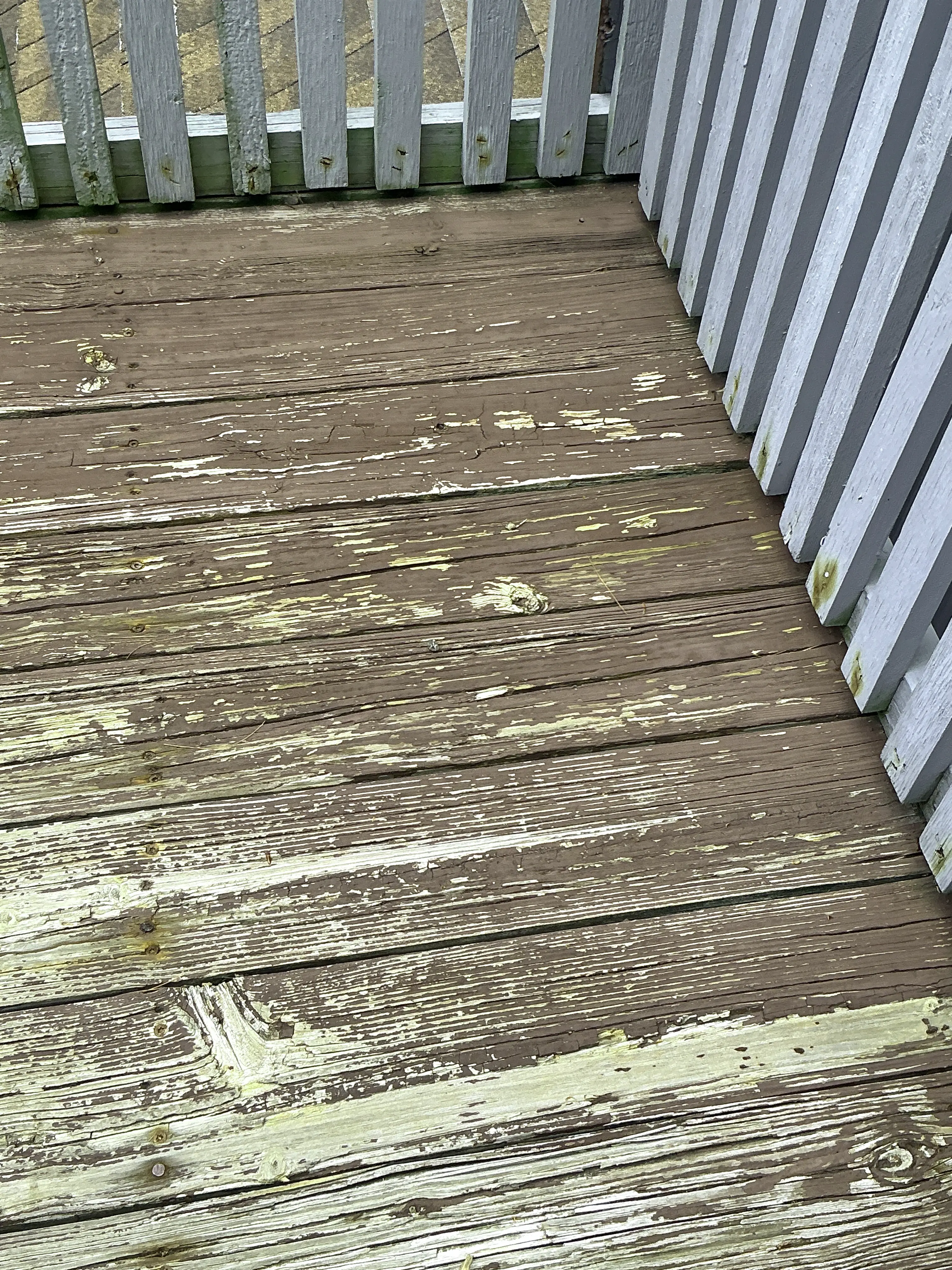 Weathered wooden deck boards with peeling brown paint 2026-08-01
