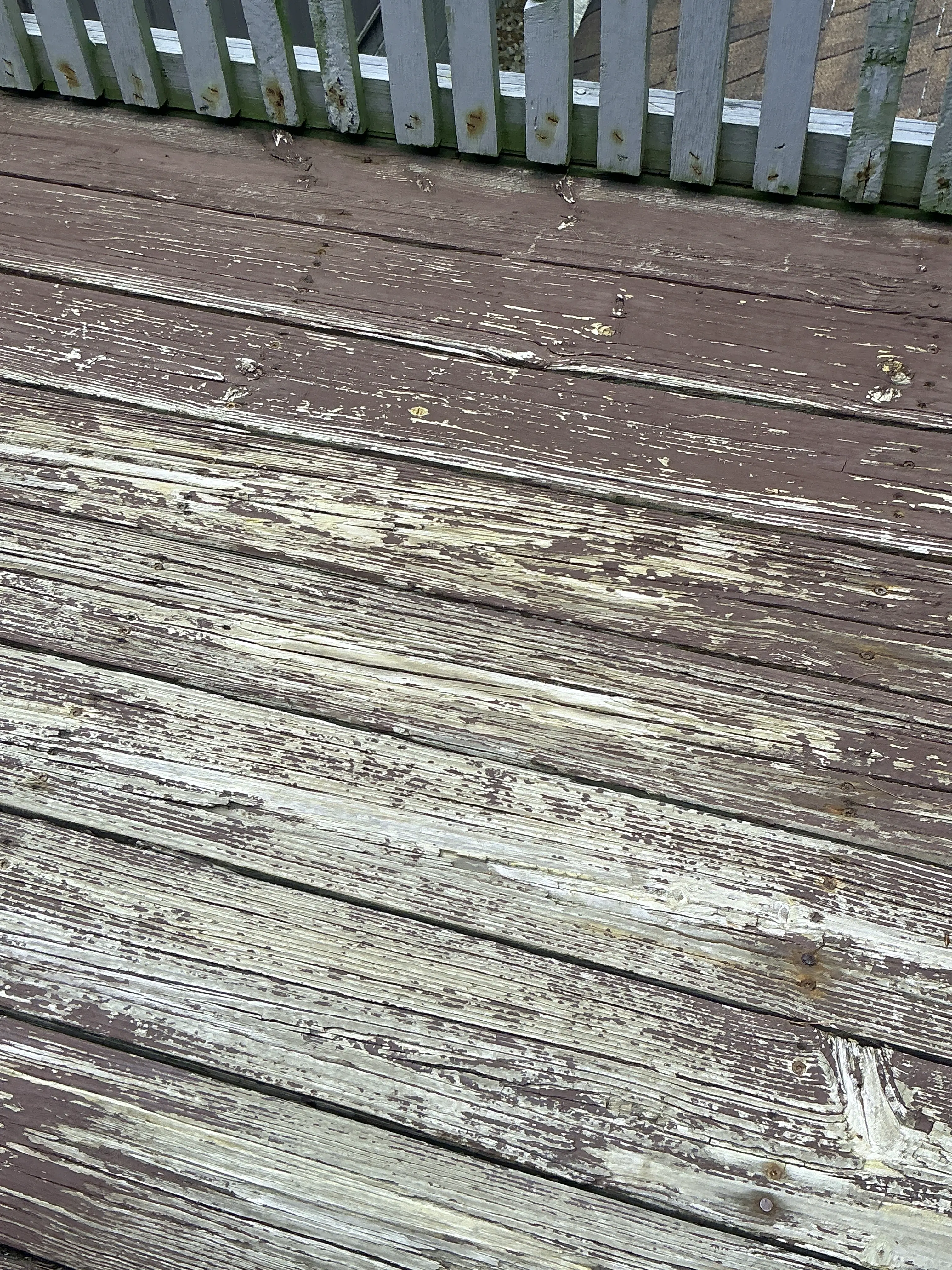 Weathered wooden deck boards with peeling paint during home inspection. 2026-07-28