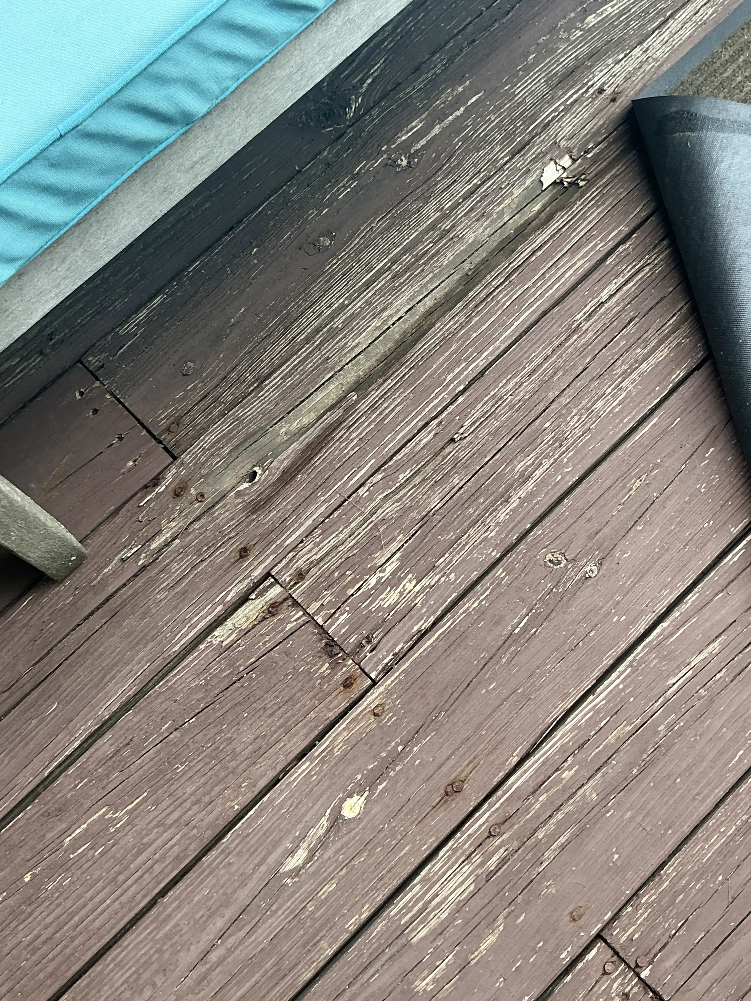 Weathered wooden deck boards with peeling finish needing repair and restaining 2026-07-08