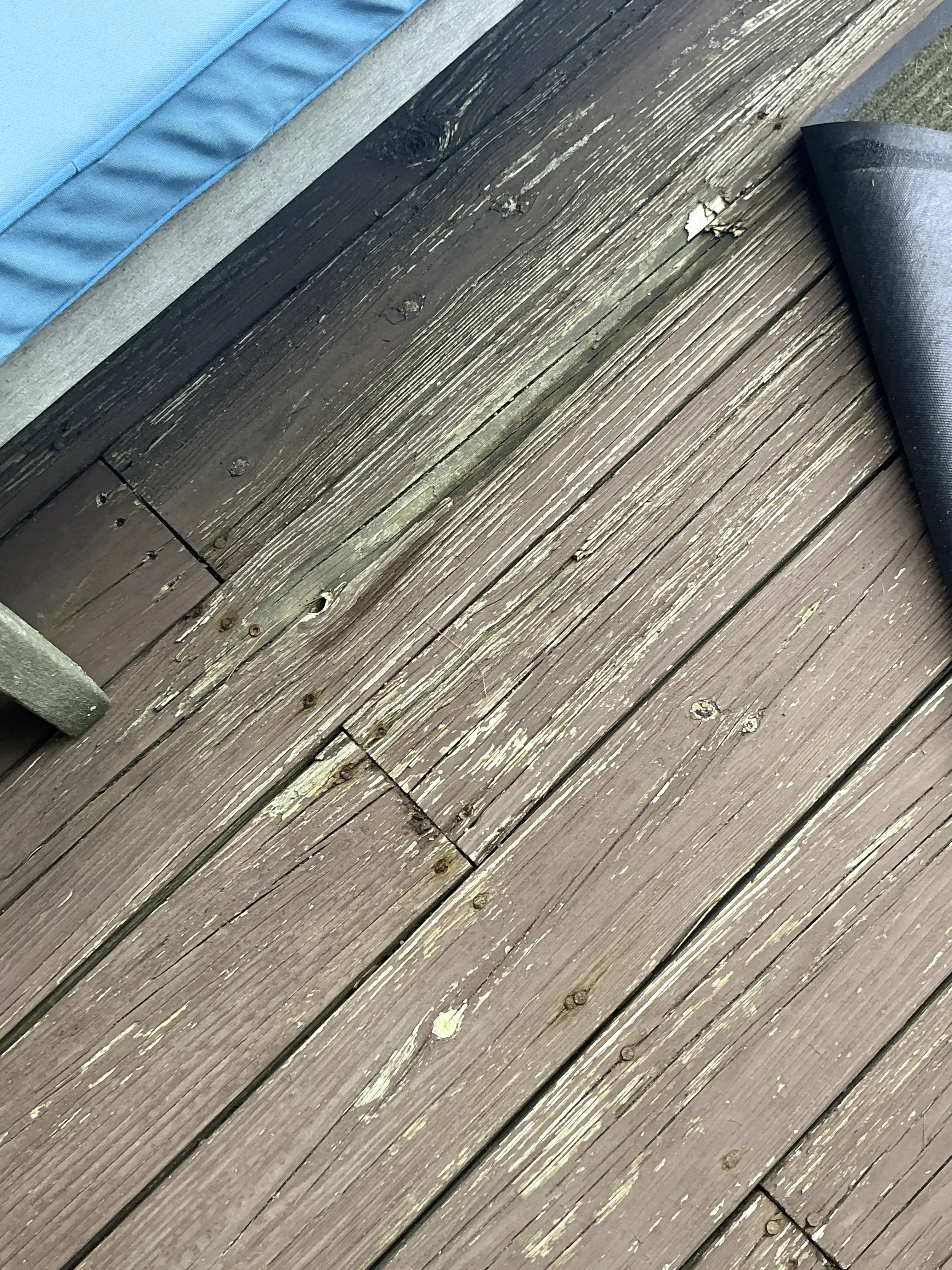 Weathered wooden deck boards with peeling finish needing repair and restaining 2026-08-01