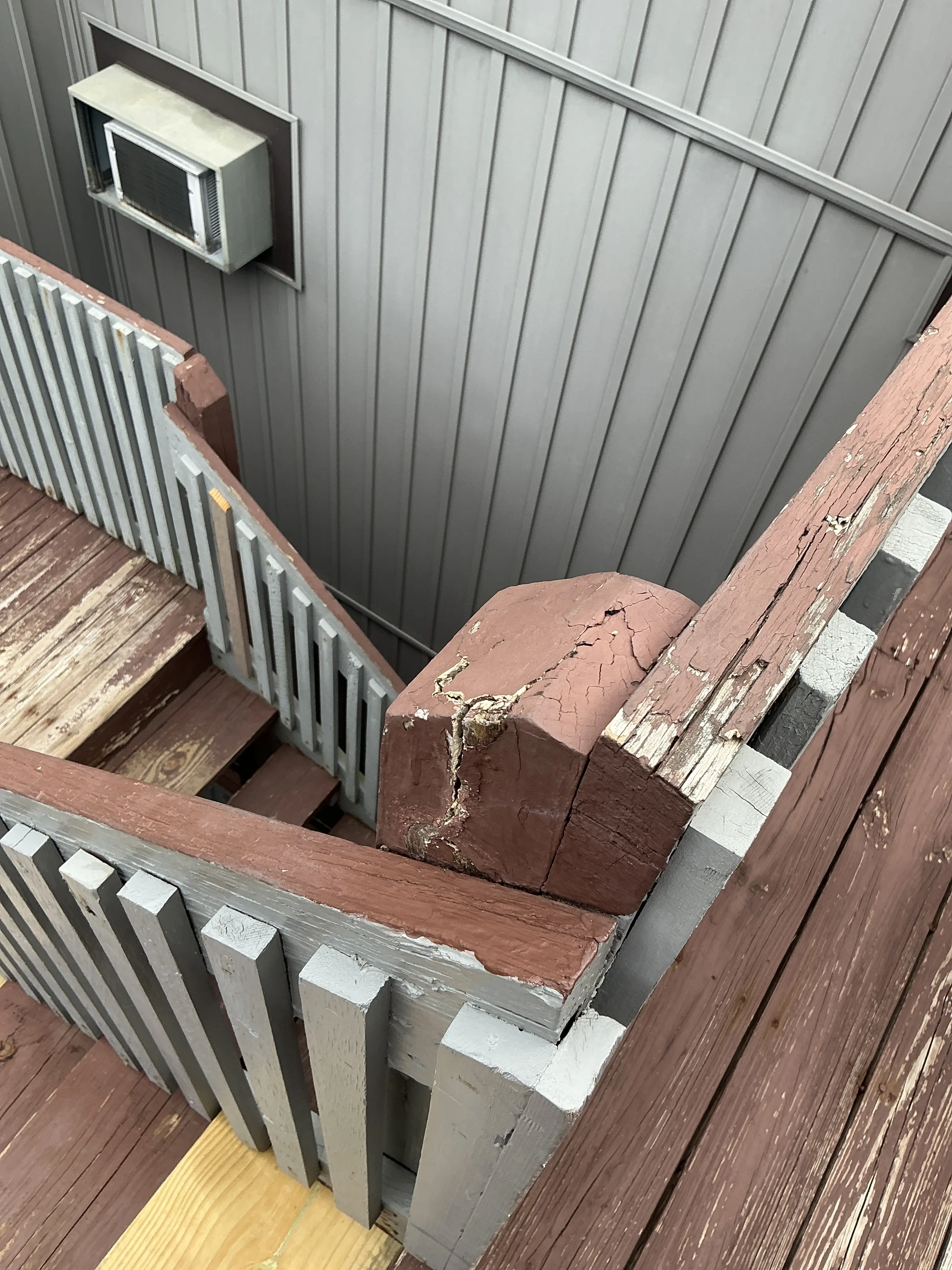 Deteriorated exterior wooden deck post with cracked brown paint and wood decay 2026-08-08