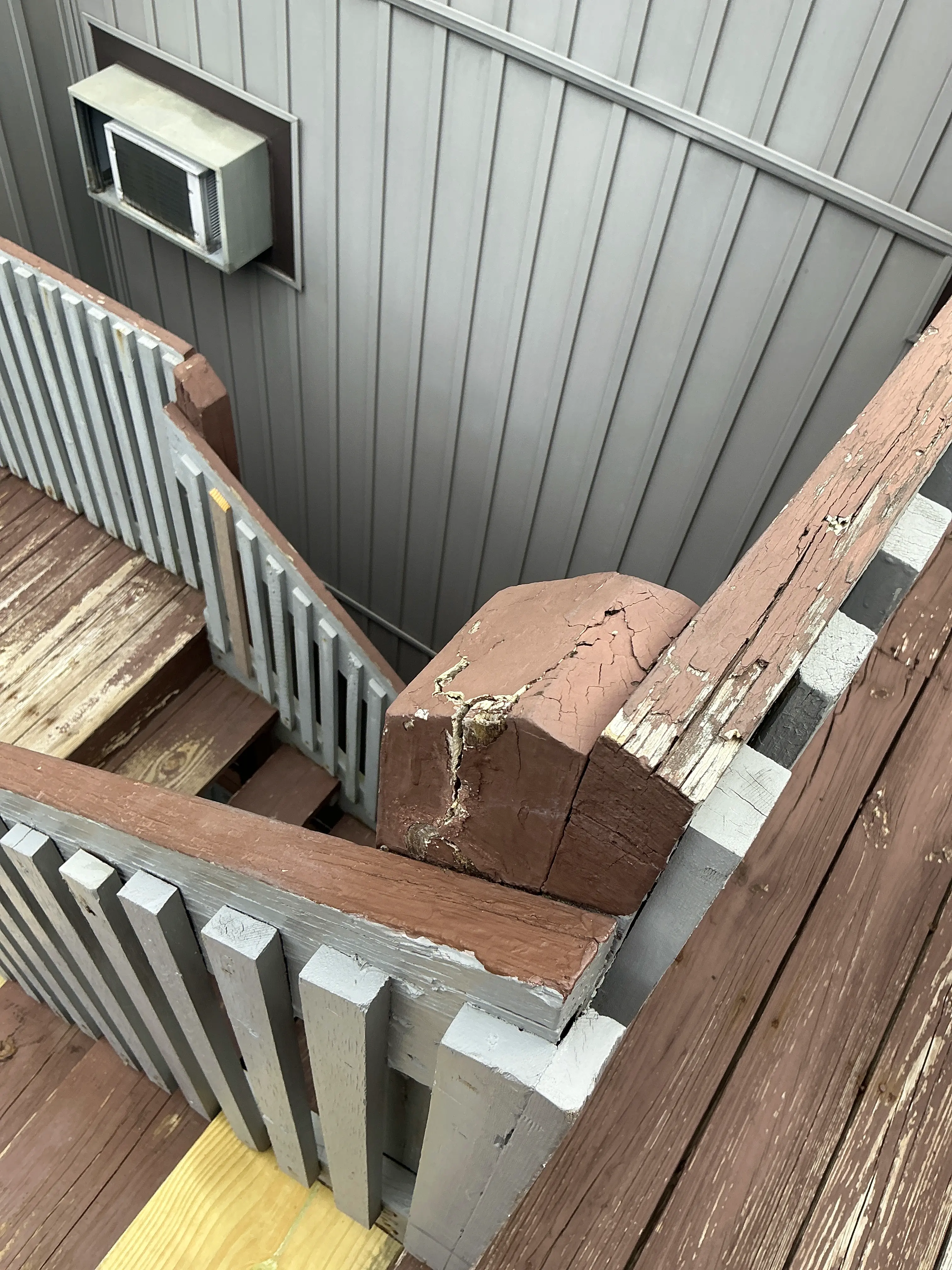 Deteriorated exterior wooden deck post with cracked brown paint and wood decay 2026-07-10
