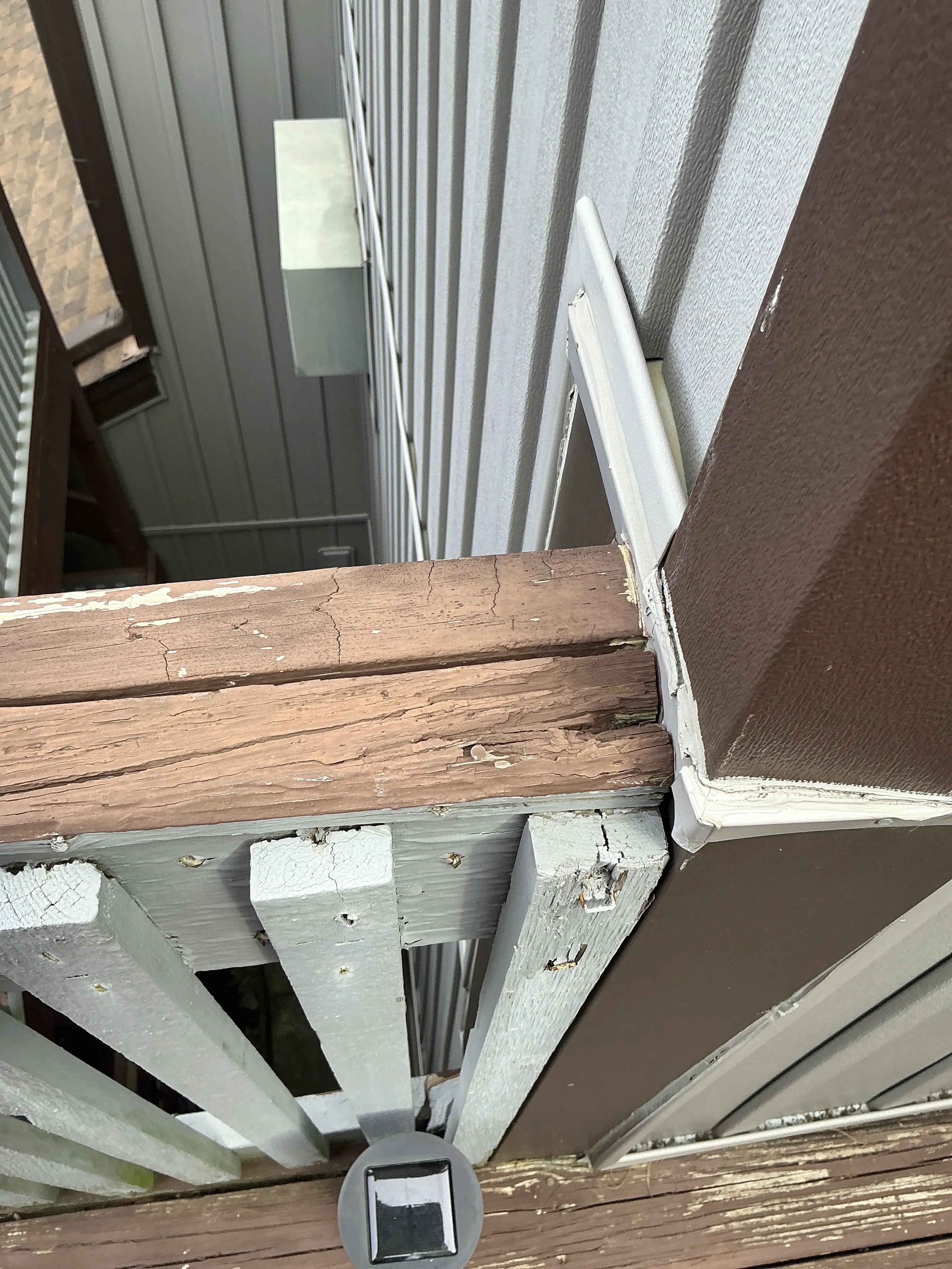 Extensive paint peeling and weathered wood decay on an exterior porch post and trim 2026-08-15