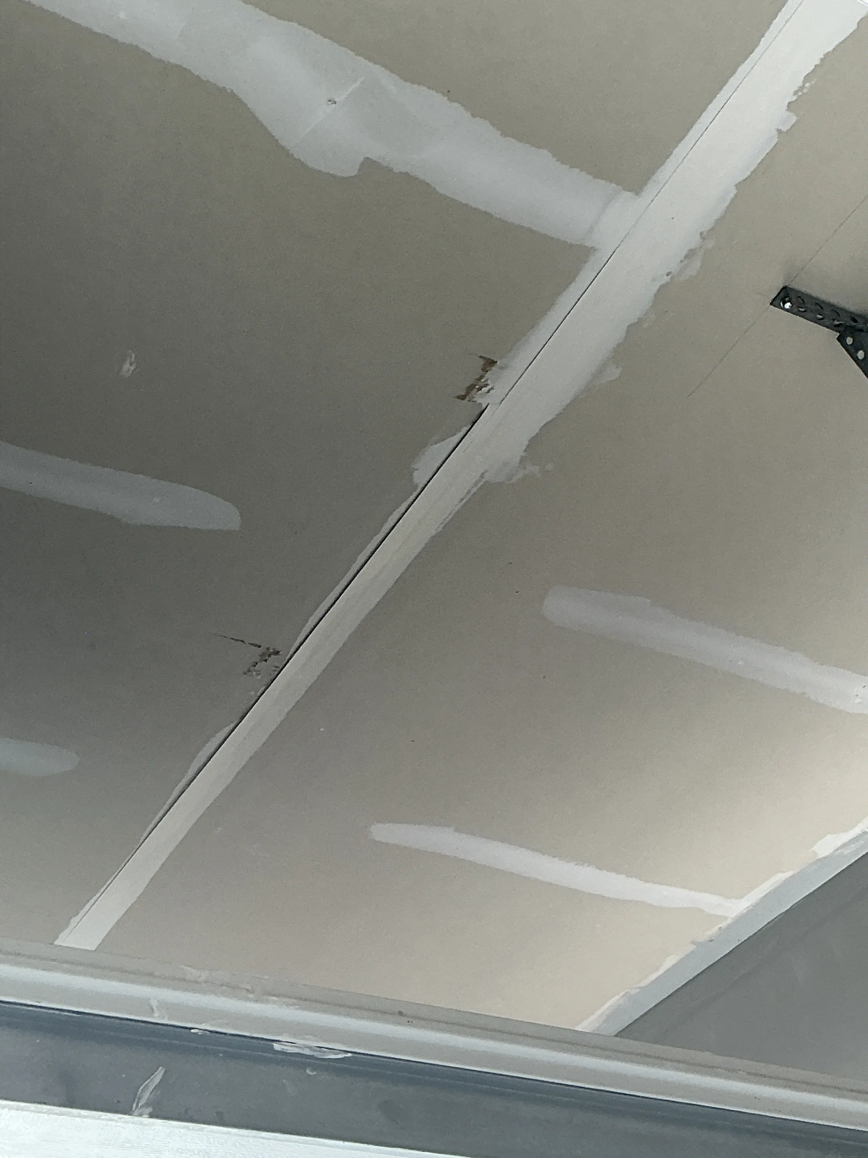 Peeling drywall joint tape and damaged seam on unfinished drywall ceiling 2026-07-31