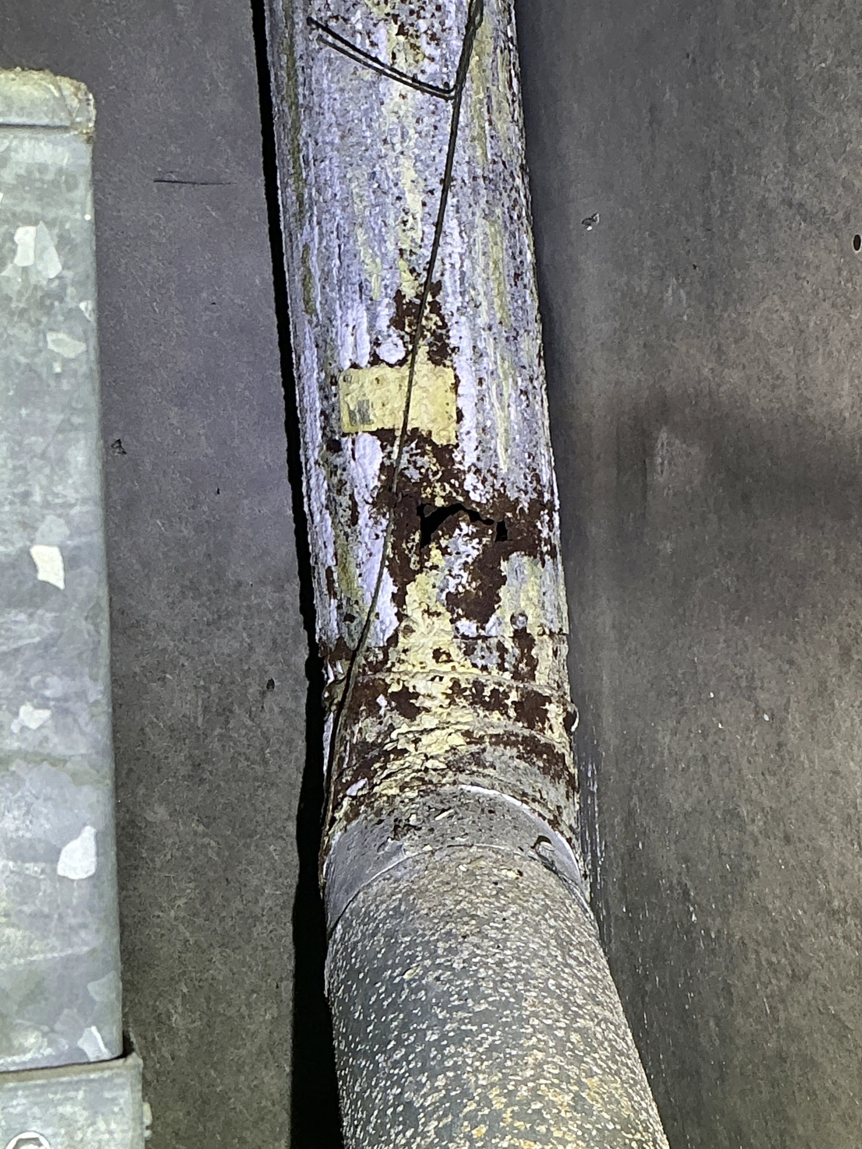 Rusted and damaged metal flue pipe with a hole discovered during a lead test 2026-08-14