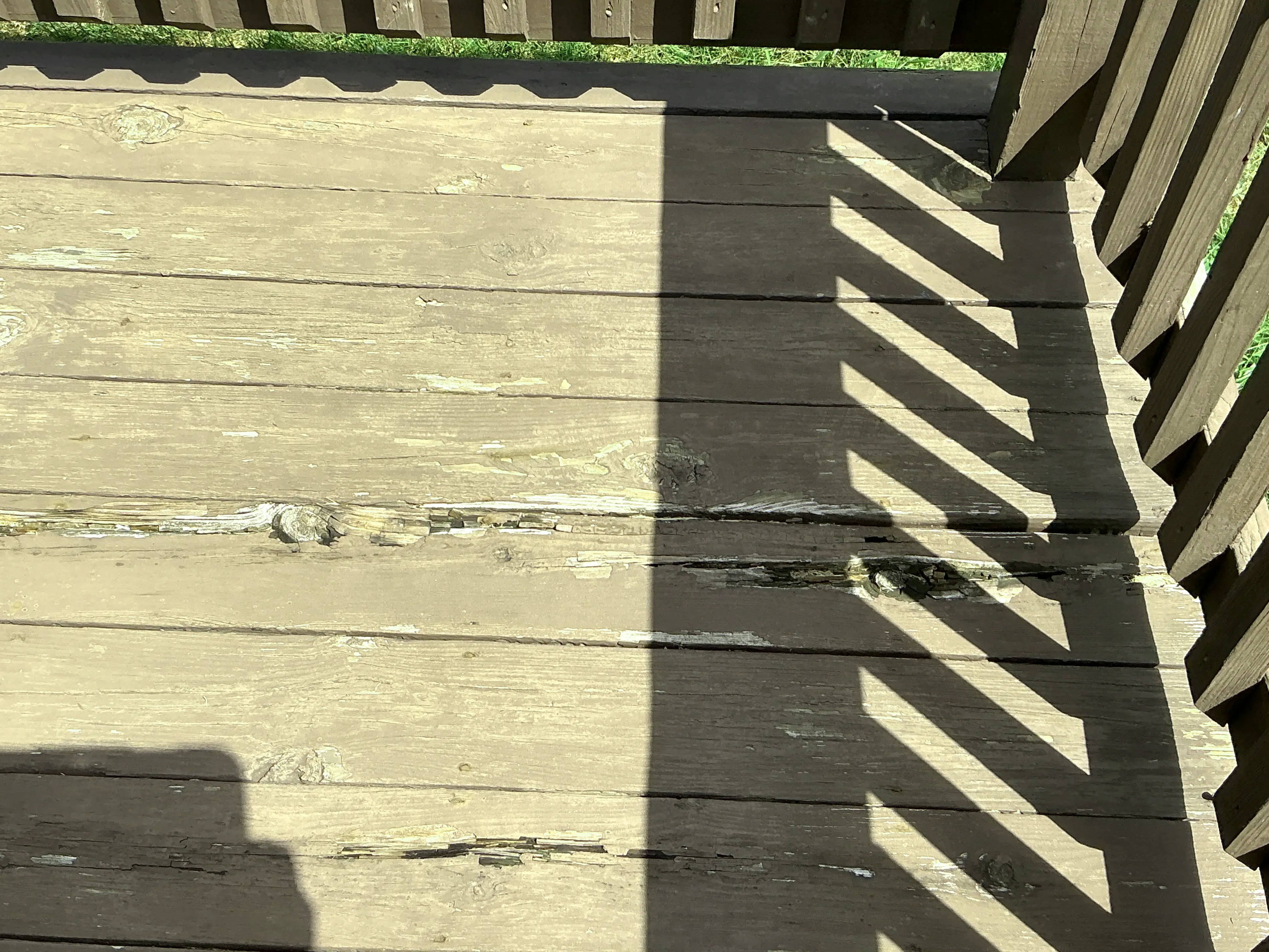 Rotted and peeling wooden deck floorboards during home inspection 2026-07-21