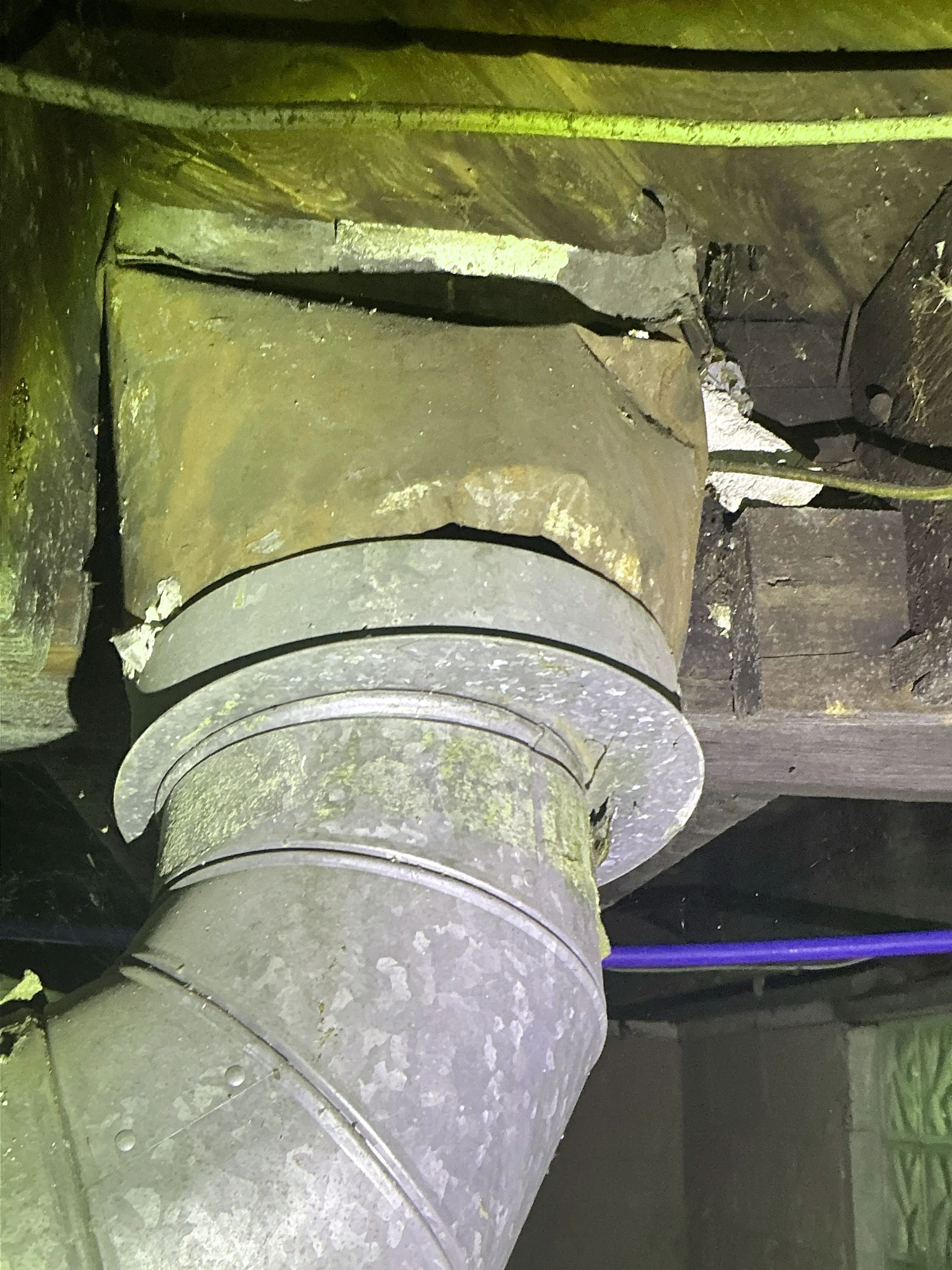 Corroded metal vent pipe entering chimney thimble near wood framing 2026-08-27