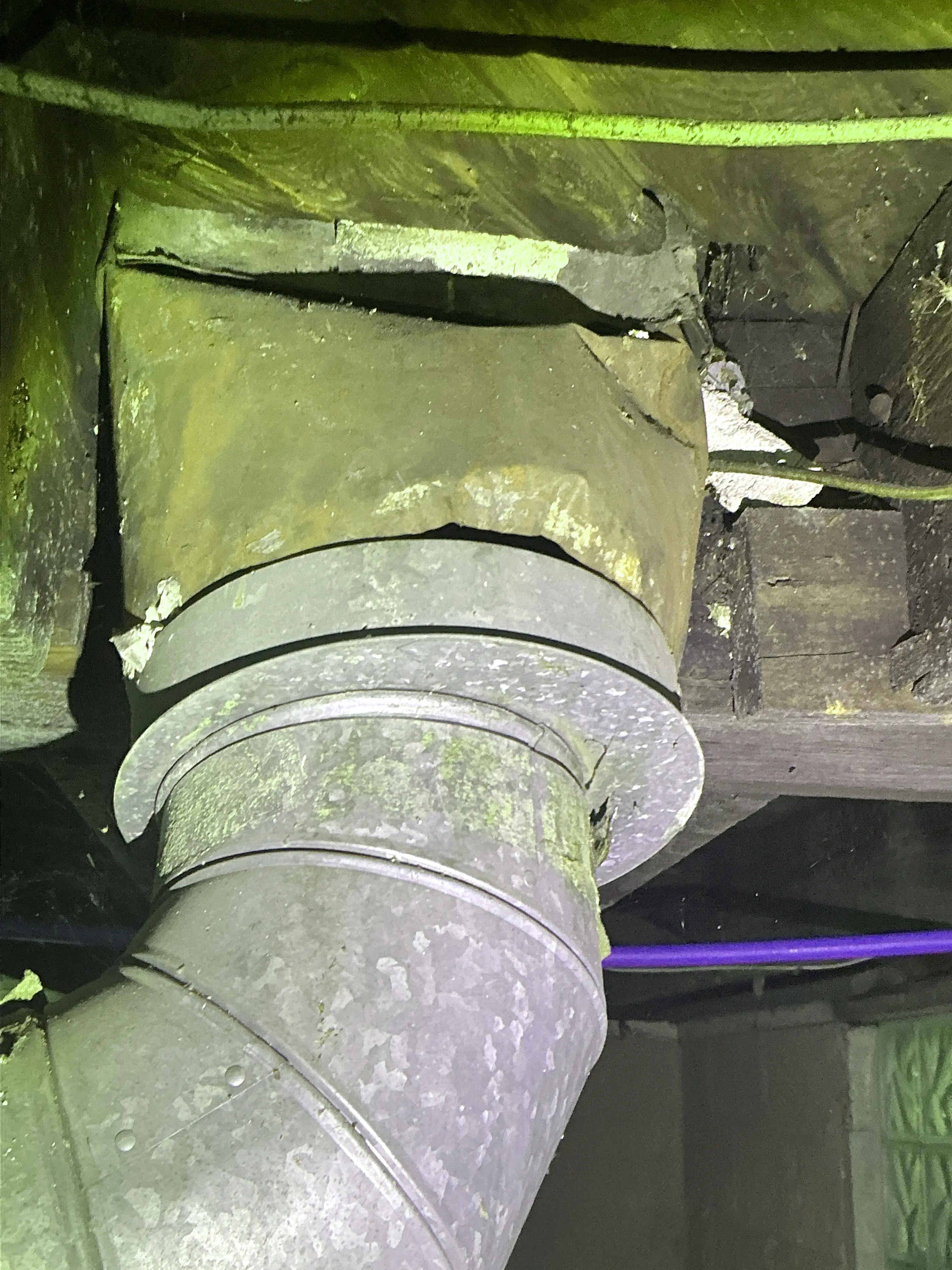 Corroded metal vent pipe entering chimney thimble near wood framing 2026-07-23