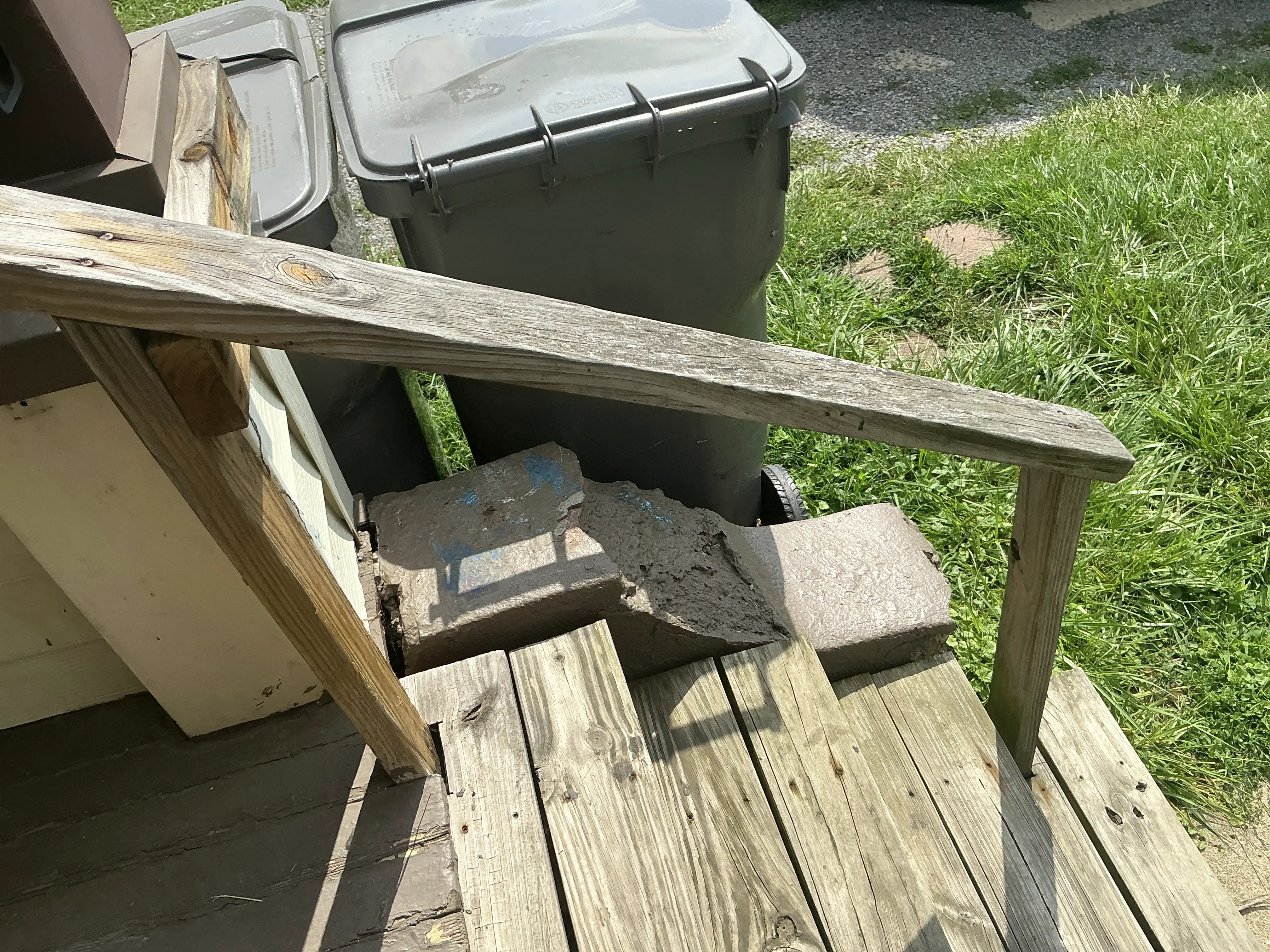 Crumbling concrete step support under weathered wooden porch railing 2026-08-07