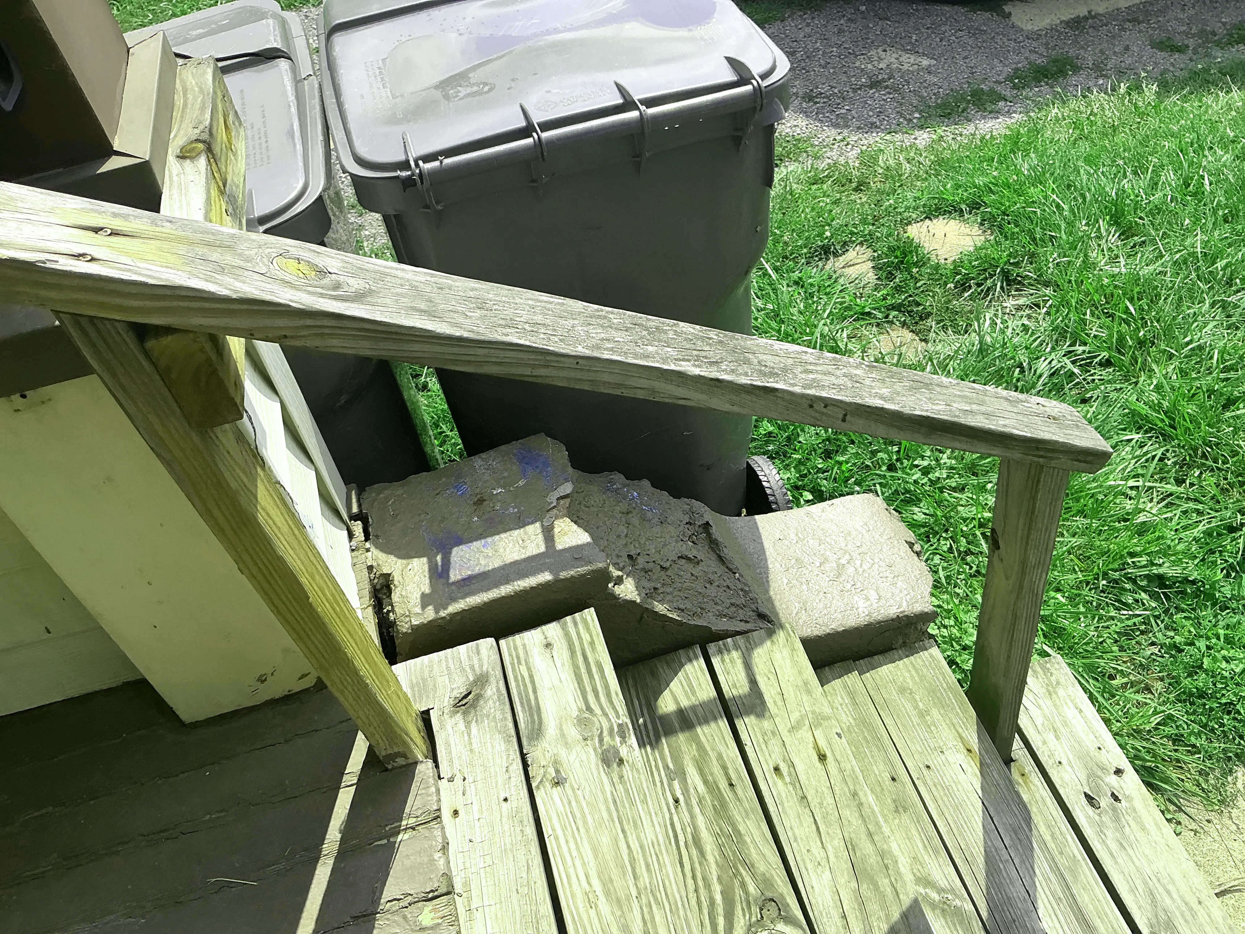 Crumbling concrete step support under weathered wooden porch railing 2026-08-15