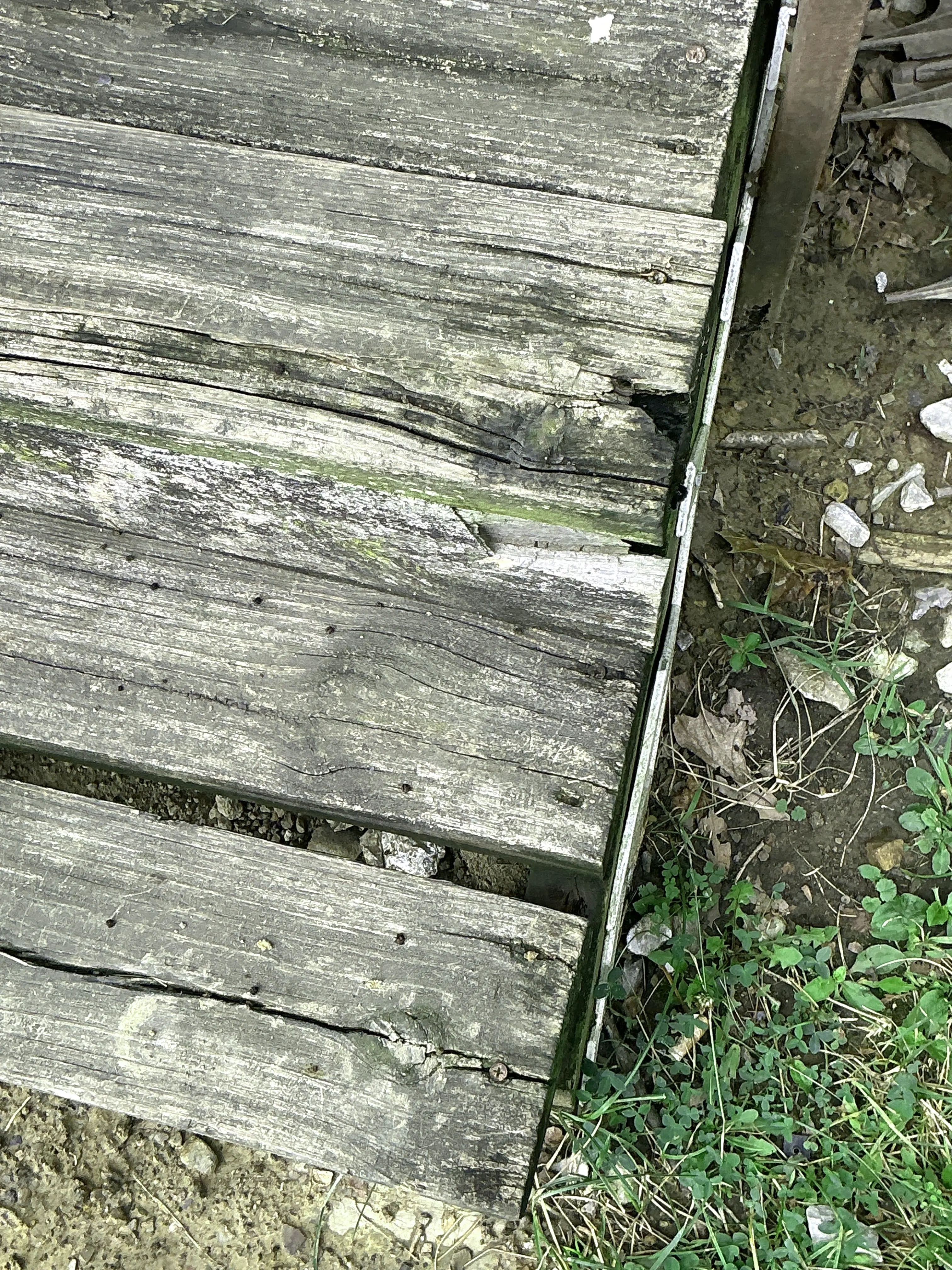 Deteriorated wooden deck boards with visible cracks and wood rot during home inspection 2026-08-20