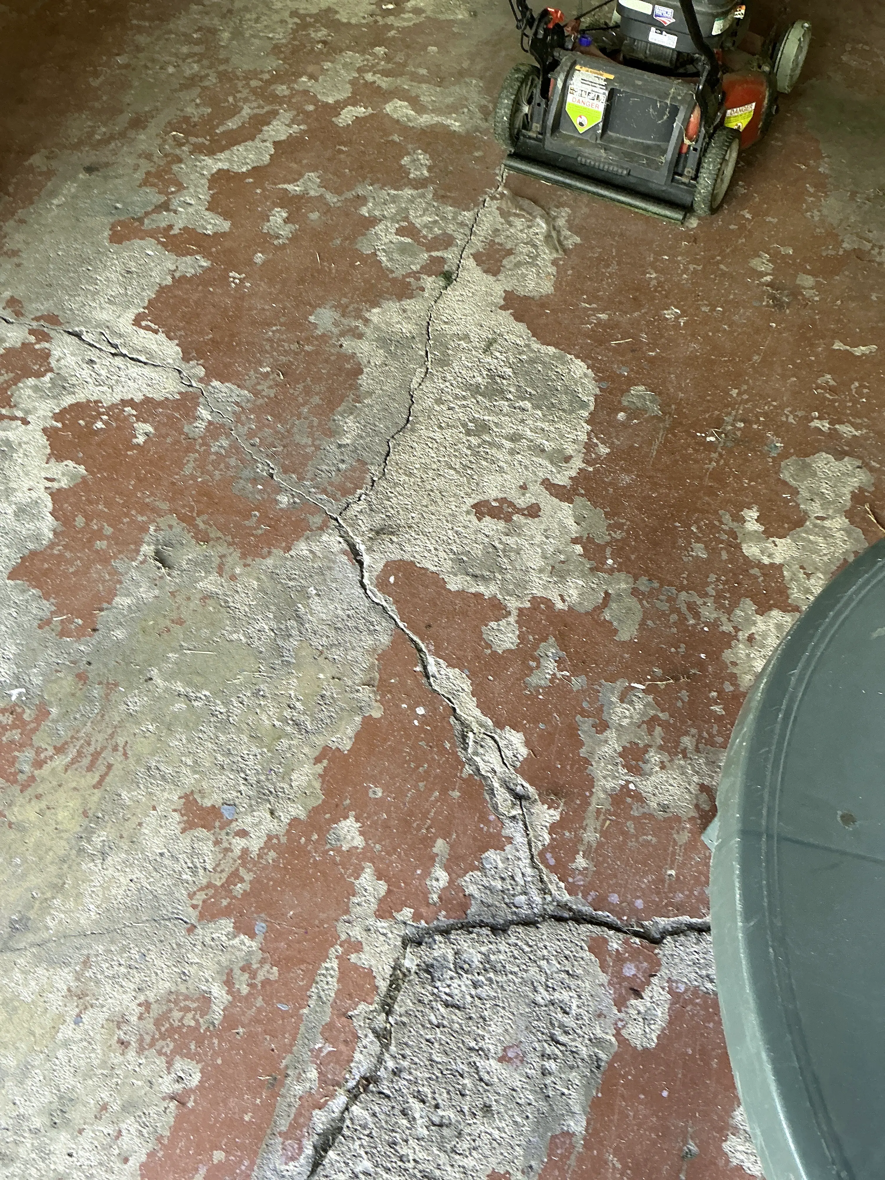 Cracked concrete garage floor with peeling red paint 2026-08-28