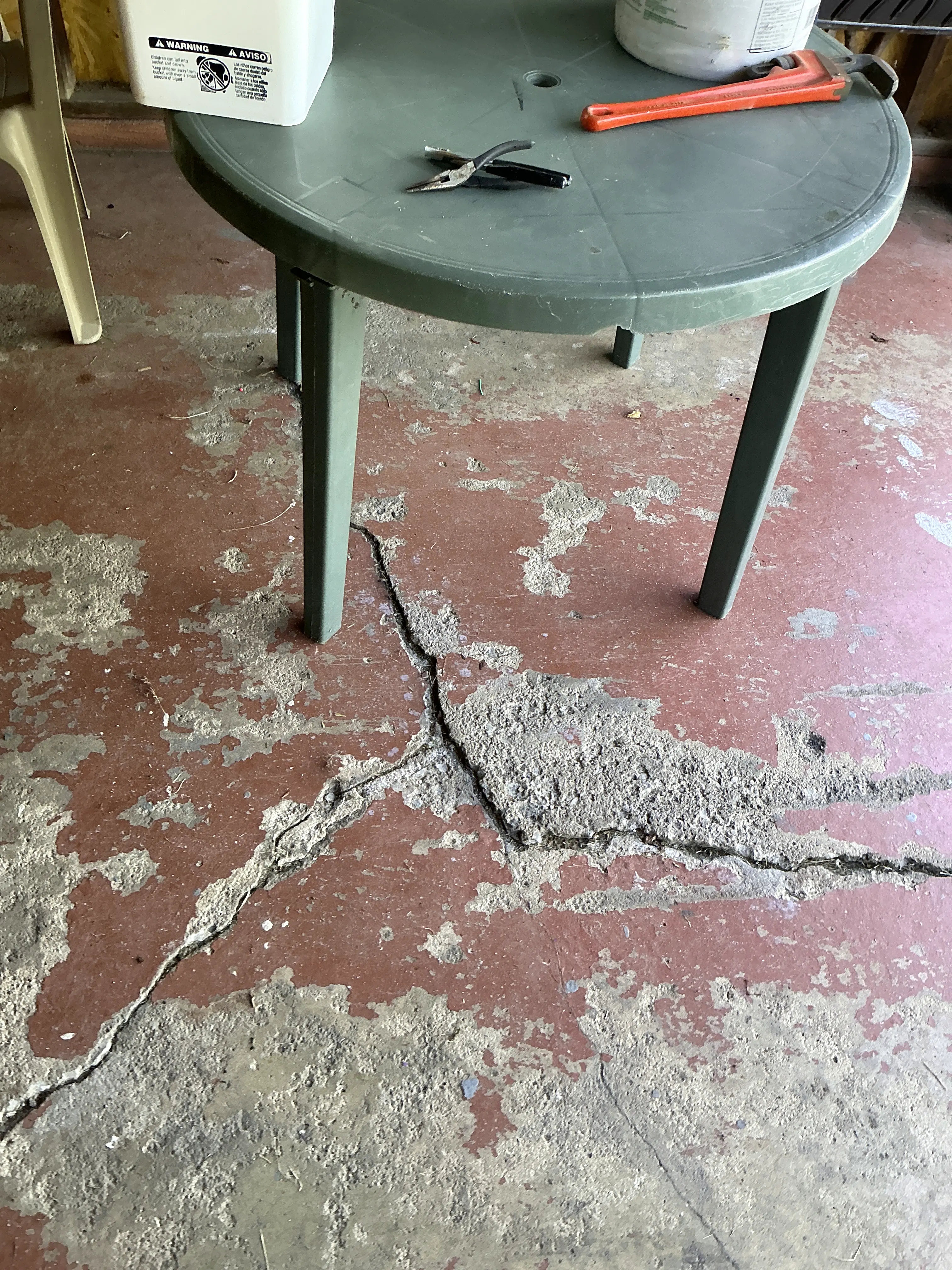 Large cracks and peeling paint on a concrete garage floor during a lead inspection 2026-09-02