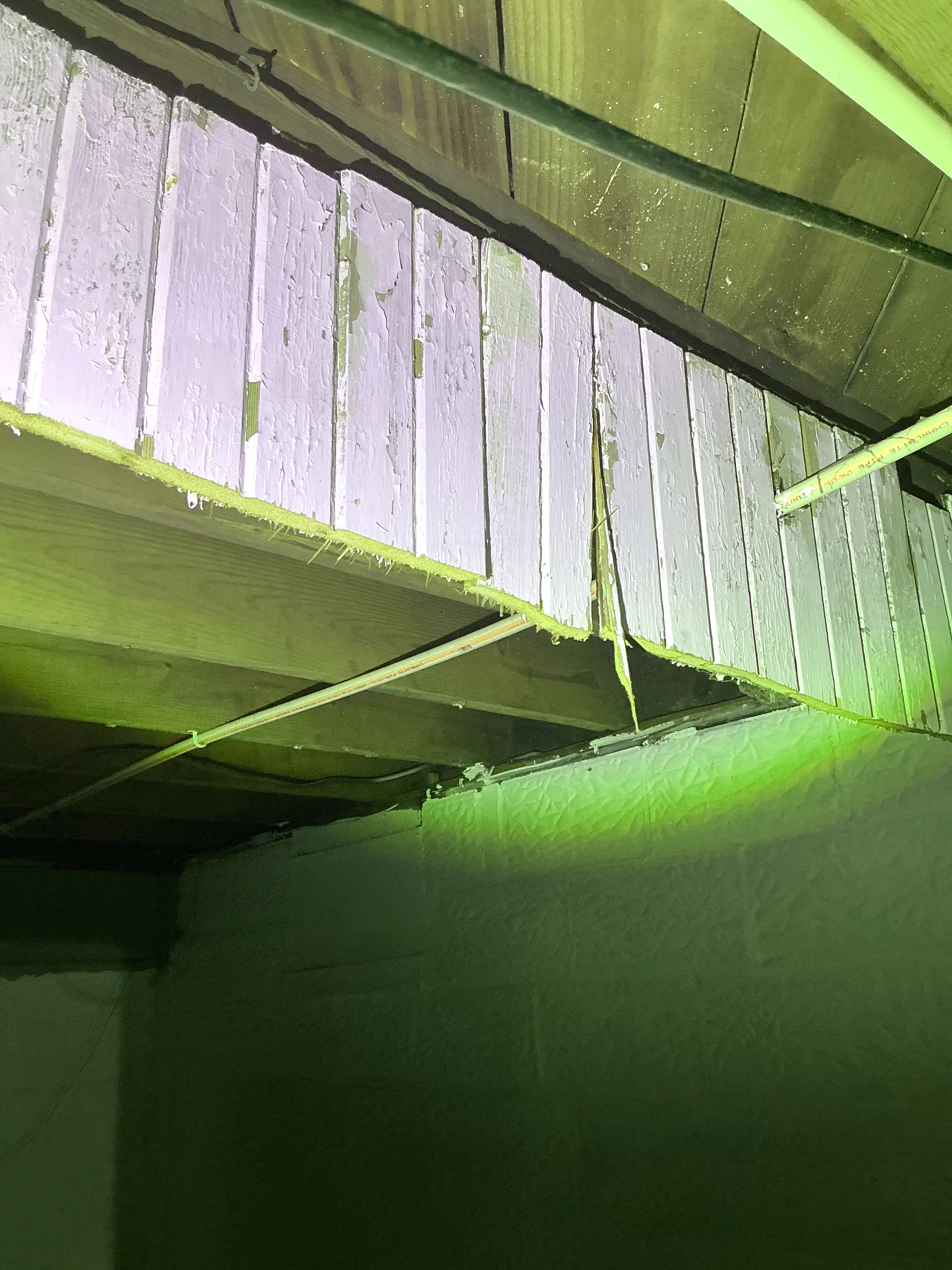 Damaged wooden soffit panels with peeling paint and exposed pipe 2026-08-20