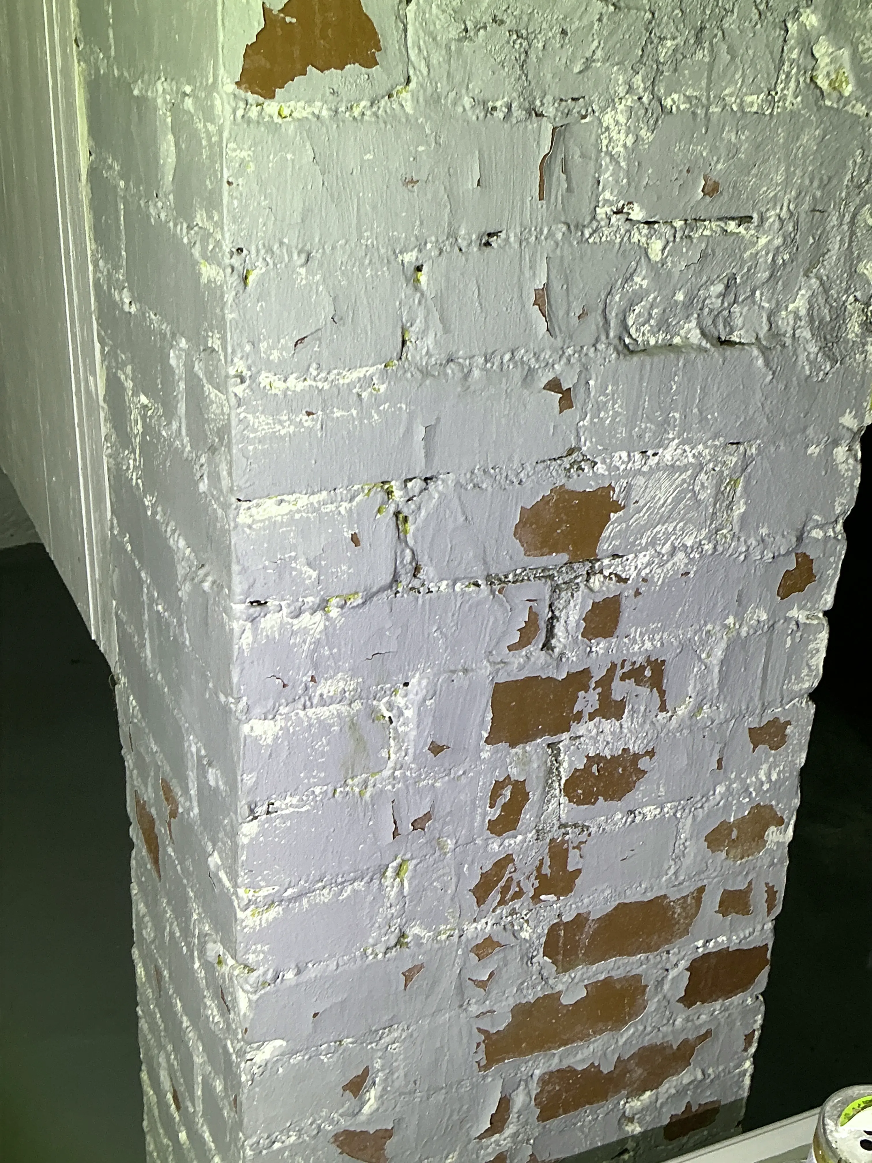 Peeling paint flaking off painted red brick structure during mold inspection 2026-08-16