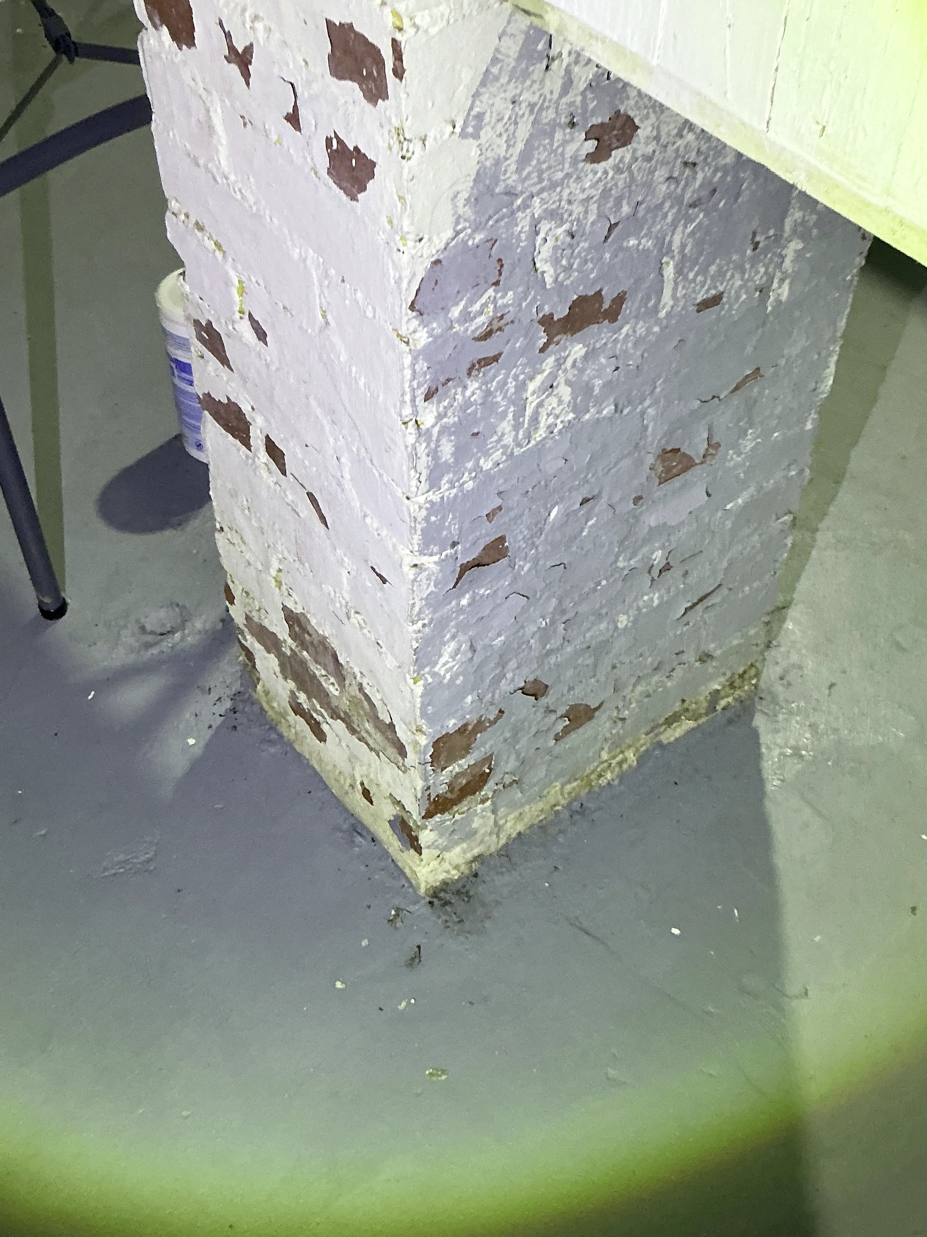 Peeling paint on painted brick pier in basement during lead inspection 2026-09-02