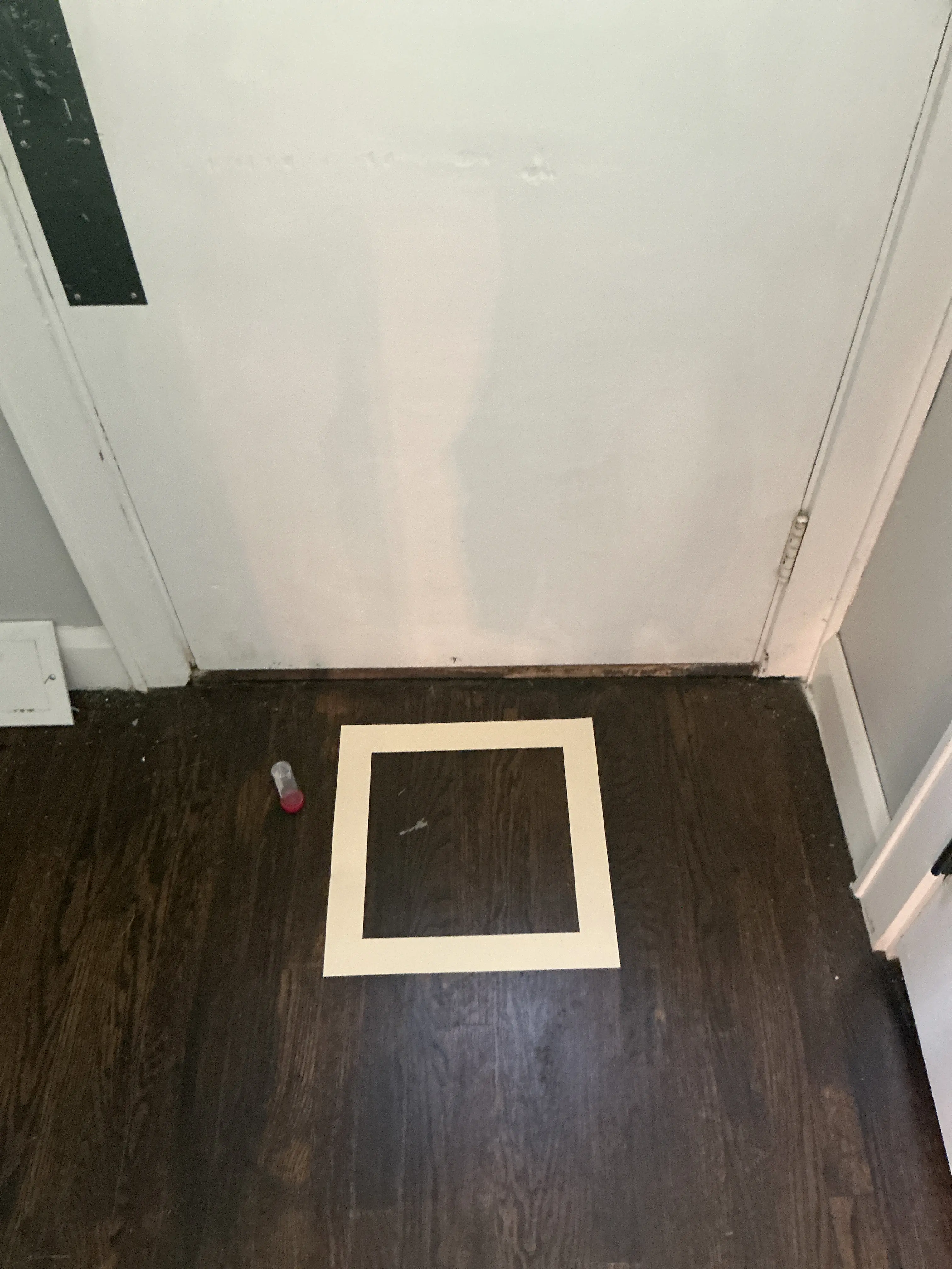 Taped surface test area on dark wood paneling with a sample collection vial during a home inspection 2026-08-05