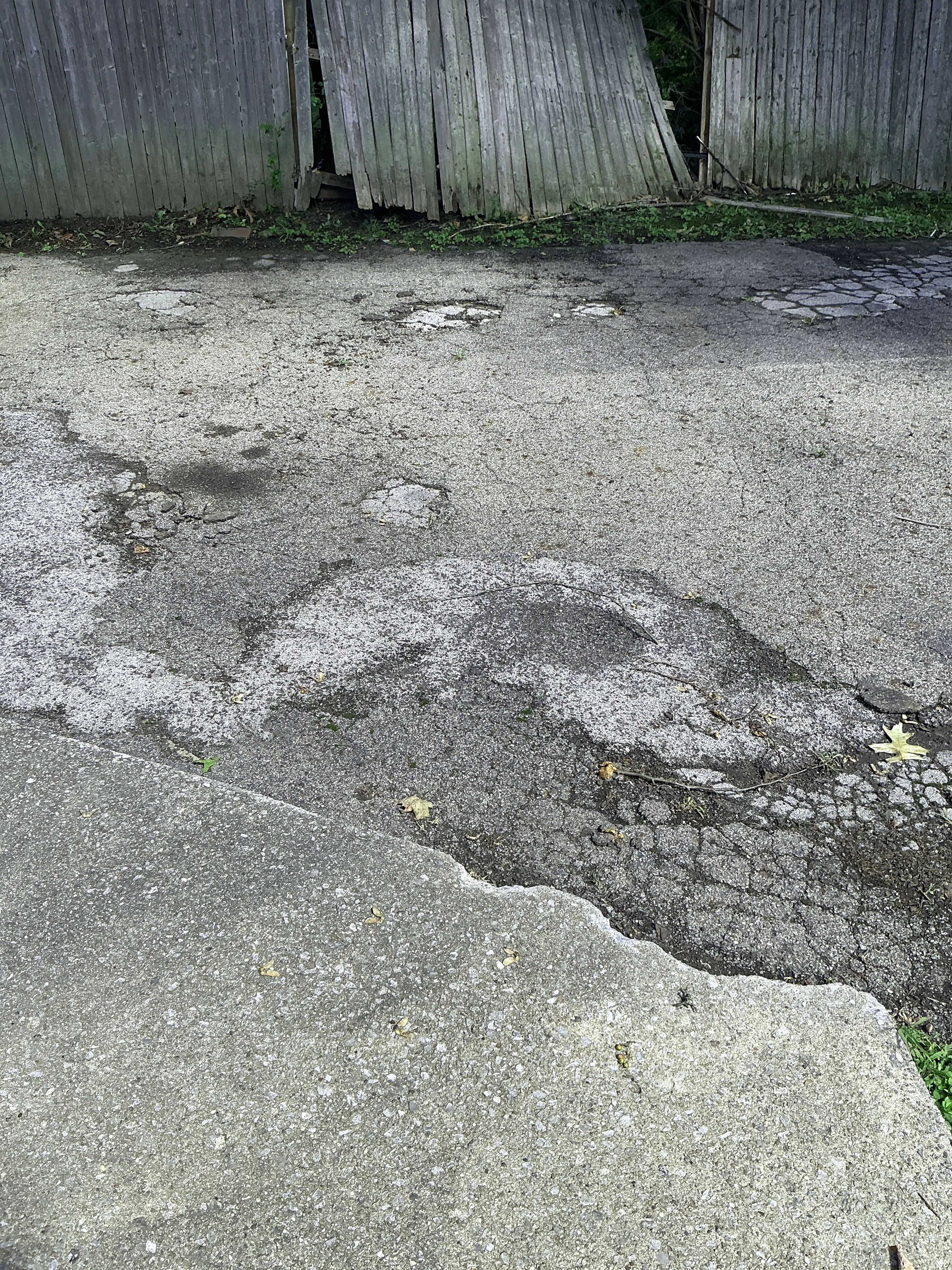 Severely cracked and worn asphalt driveway requiring repair 2026-09-01