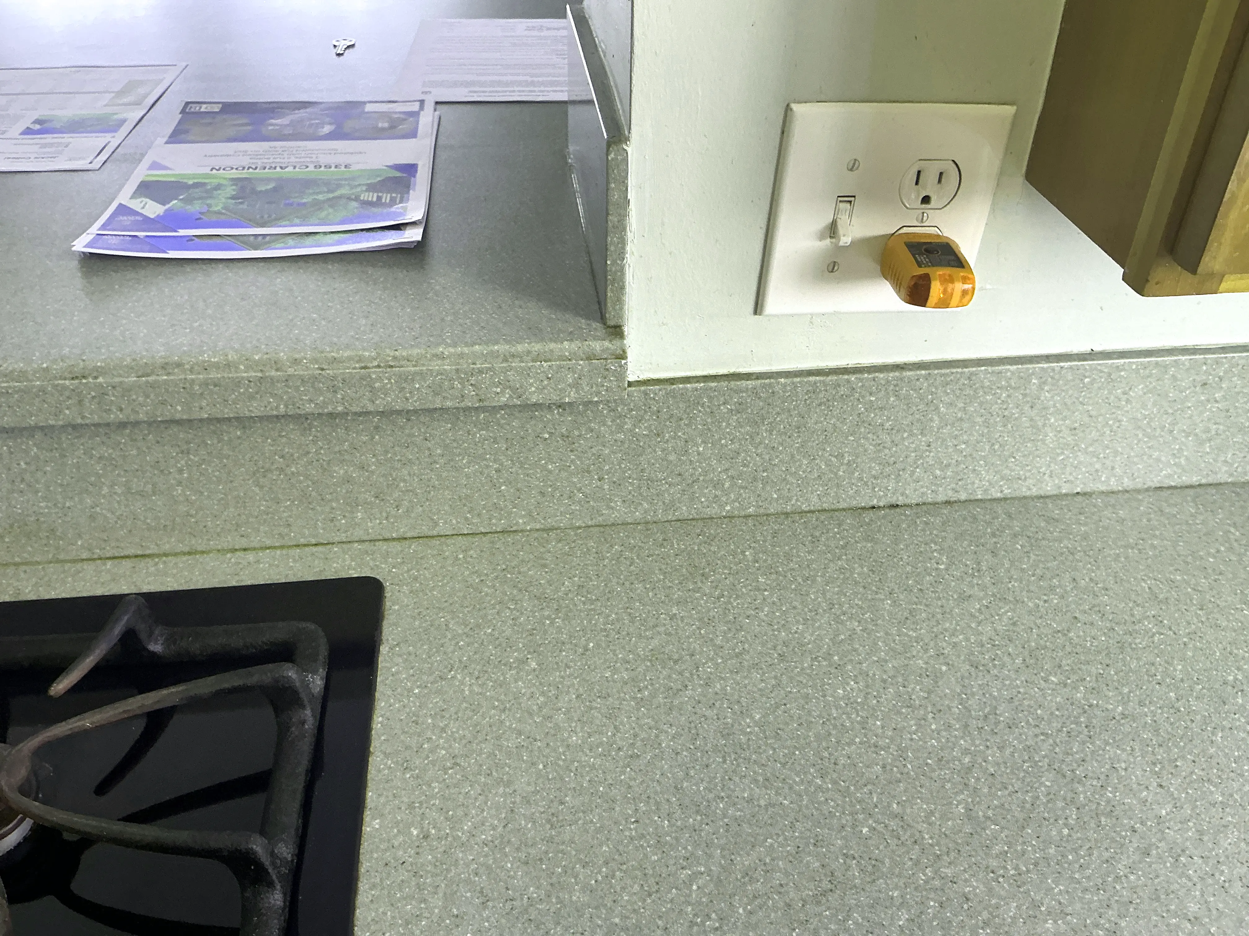 Circuit tester plugged into a white electrical outlet on a kitchen countertop backsplash 2026-07-05