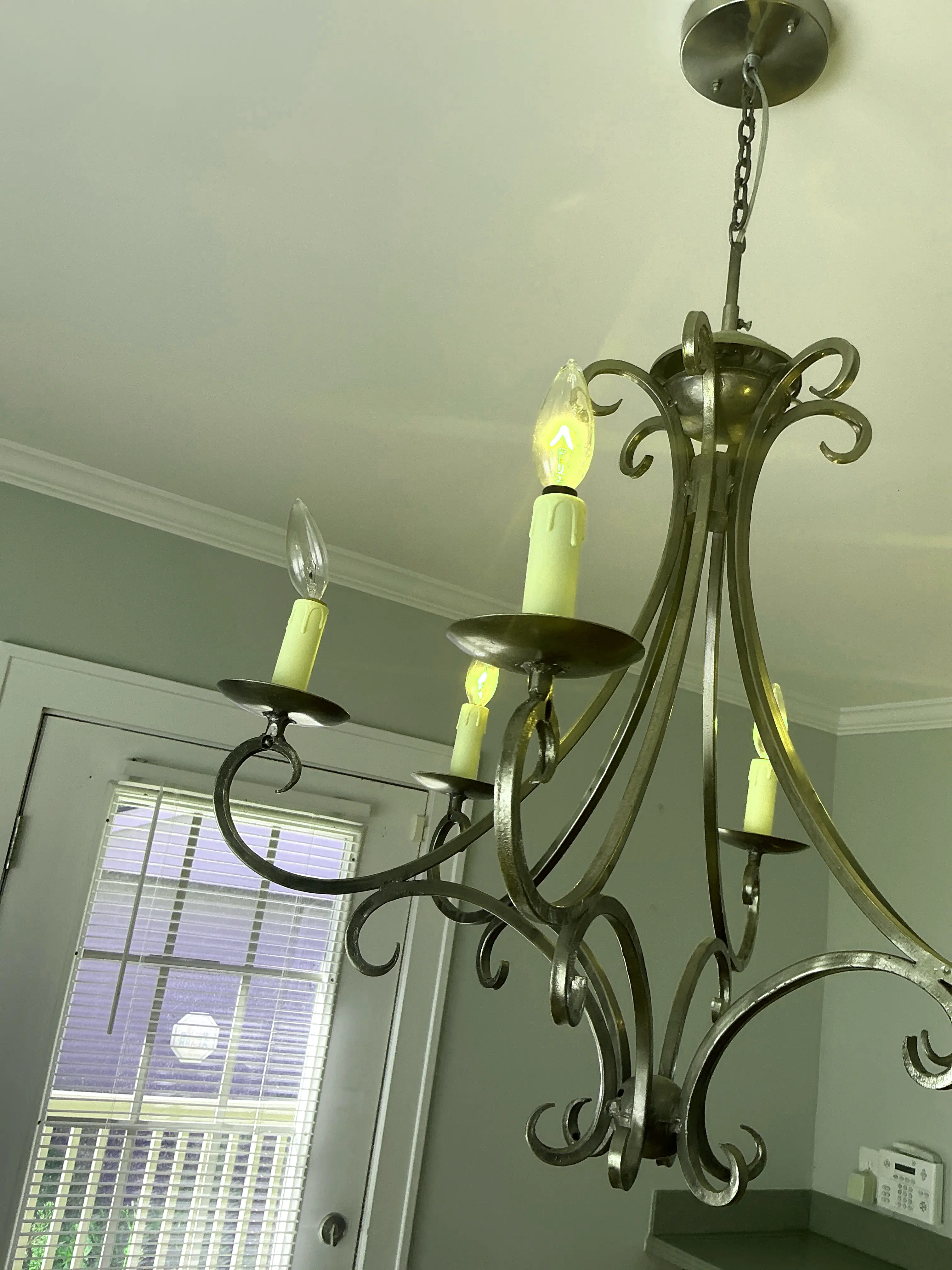 Wrought iron chandelier ceiling light fixture with a burnt-out bulb observed during a general inspection. 2026-07-30