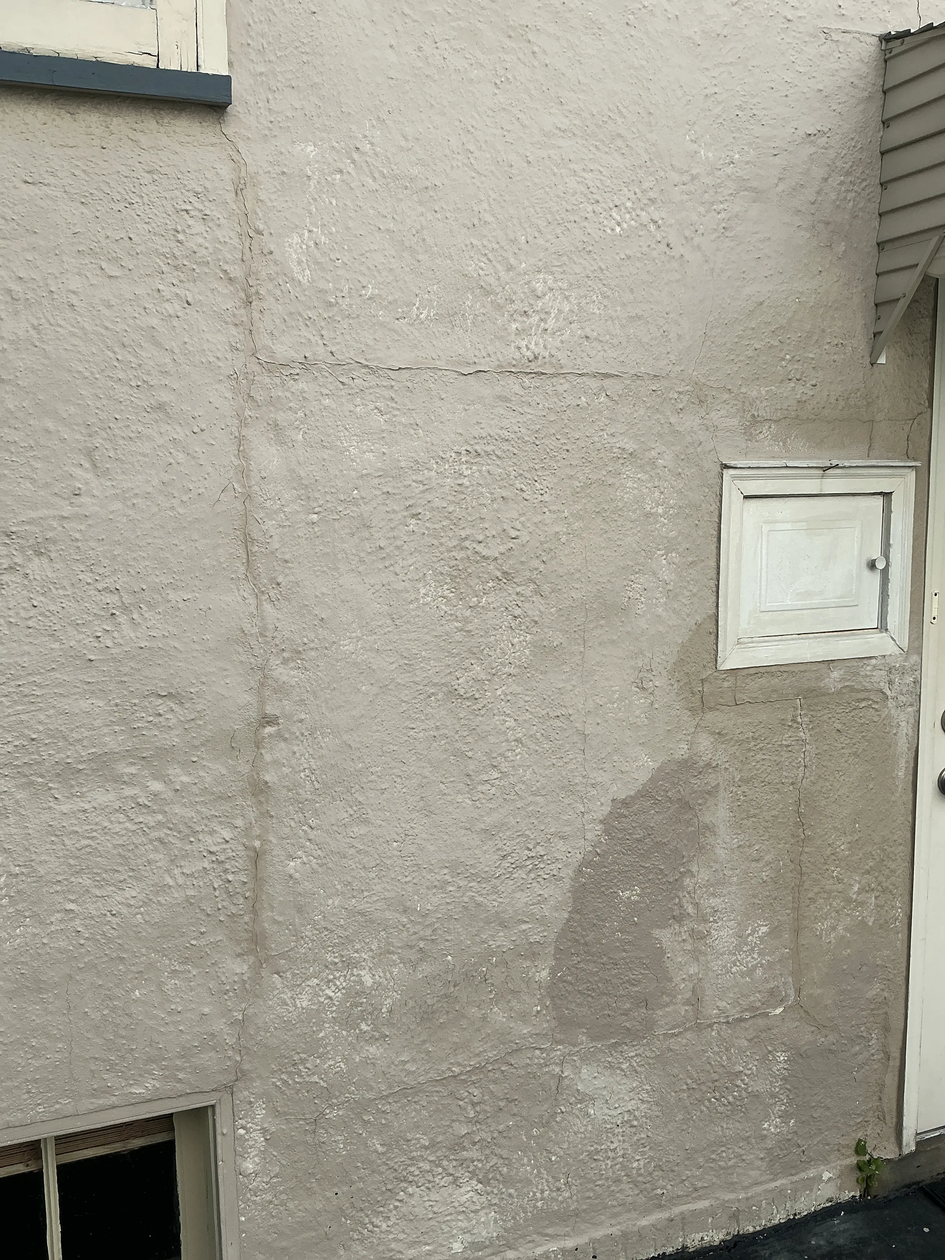 Cracks and patched stucco exterior wall observed during mold inspection 2026-07-31